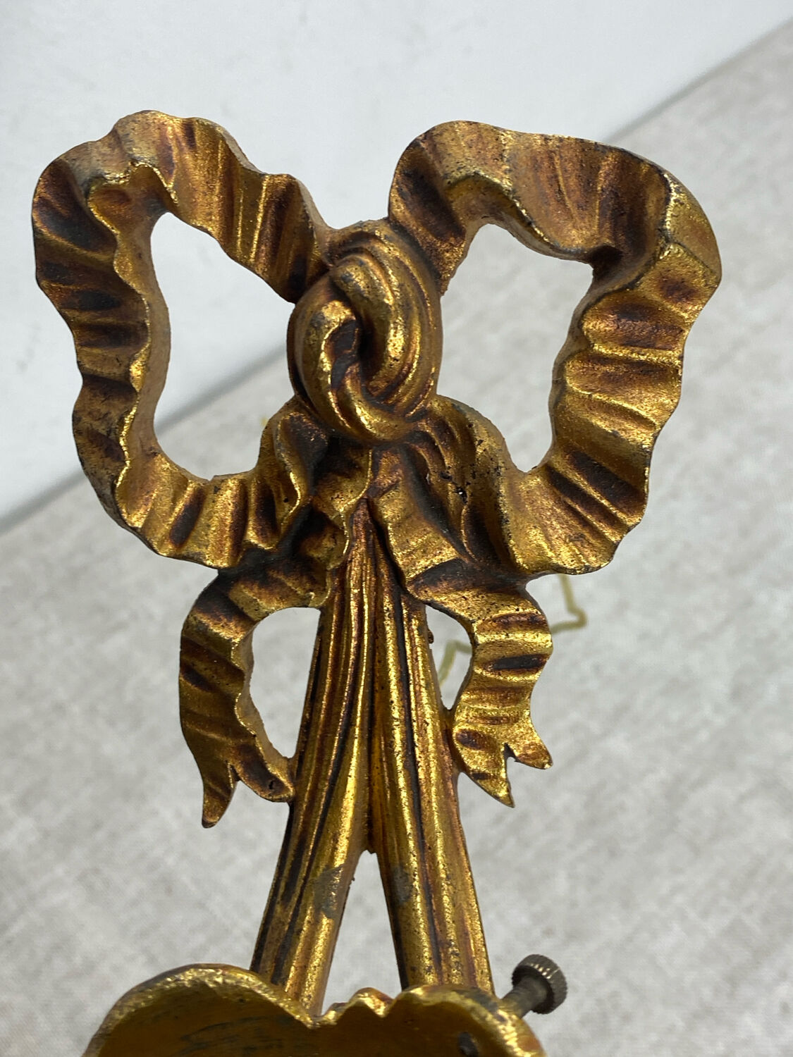 Bronze wall light, decorated with a bow and ribbon.