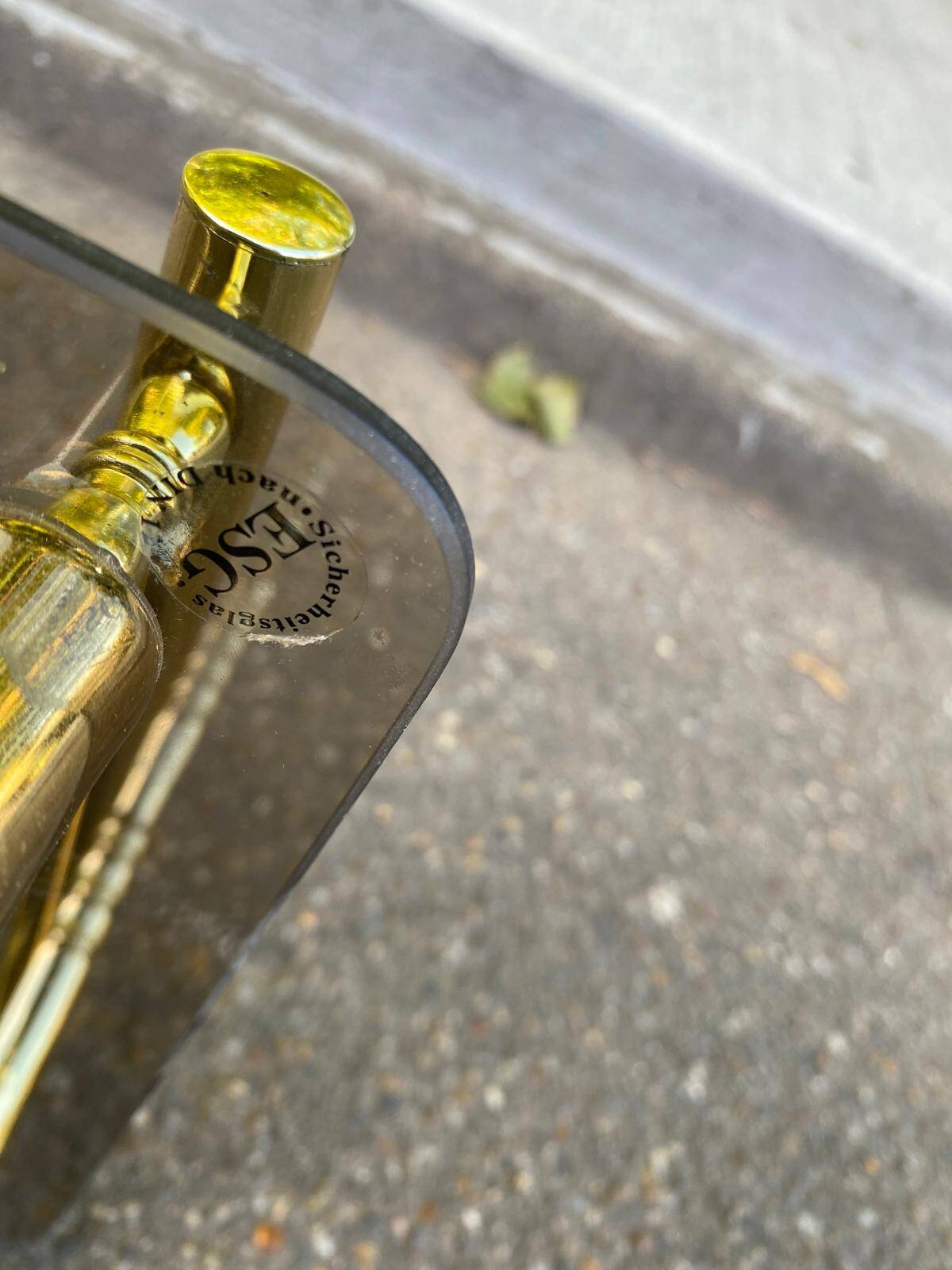 Vintage side table with smoked glass and sculpted golden brass, Hollywood Regency style.