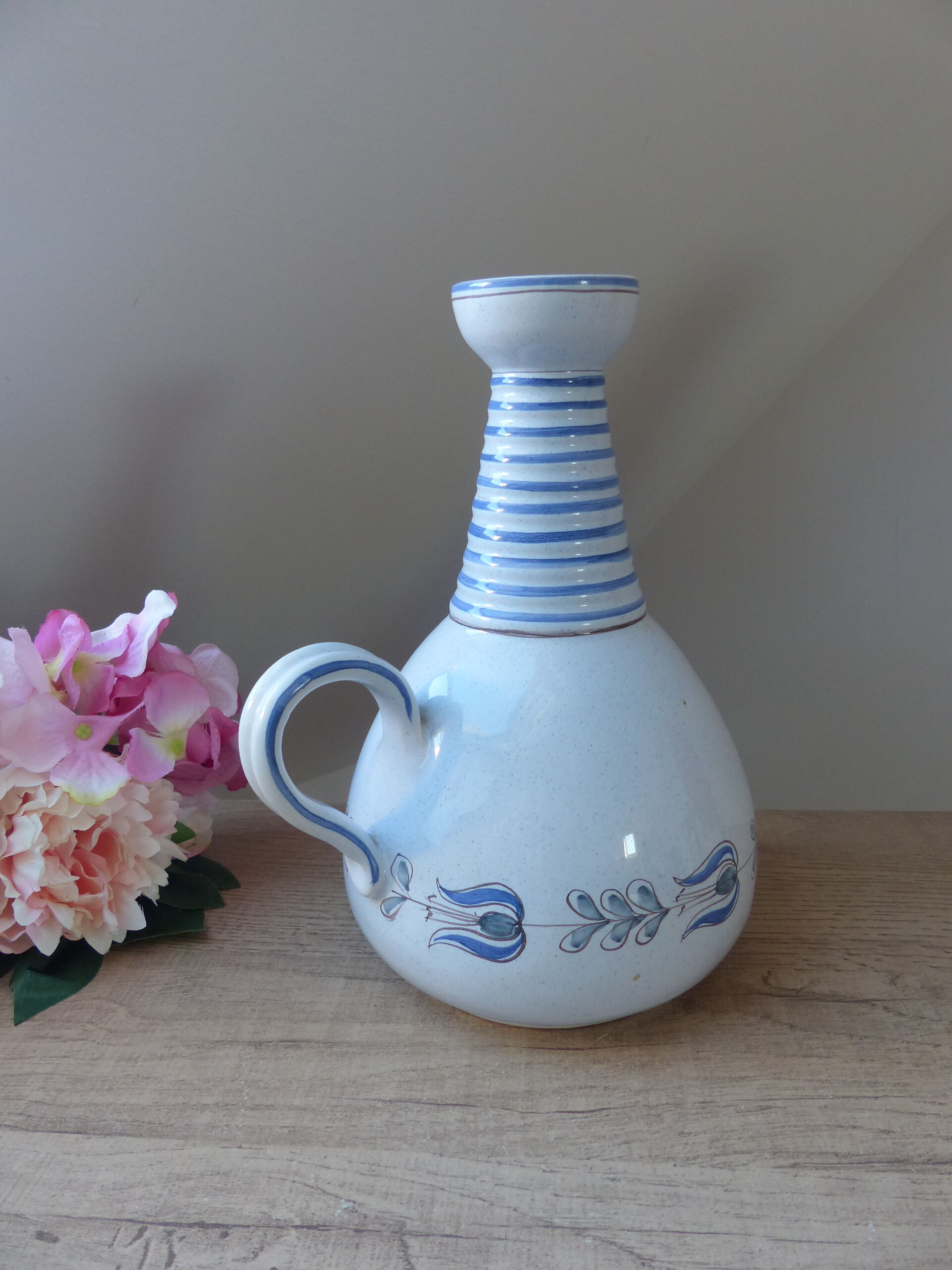 Vintage blue ceramic jug with hand-painted floral decoration.