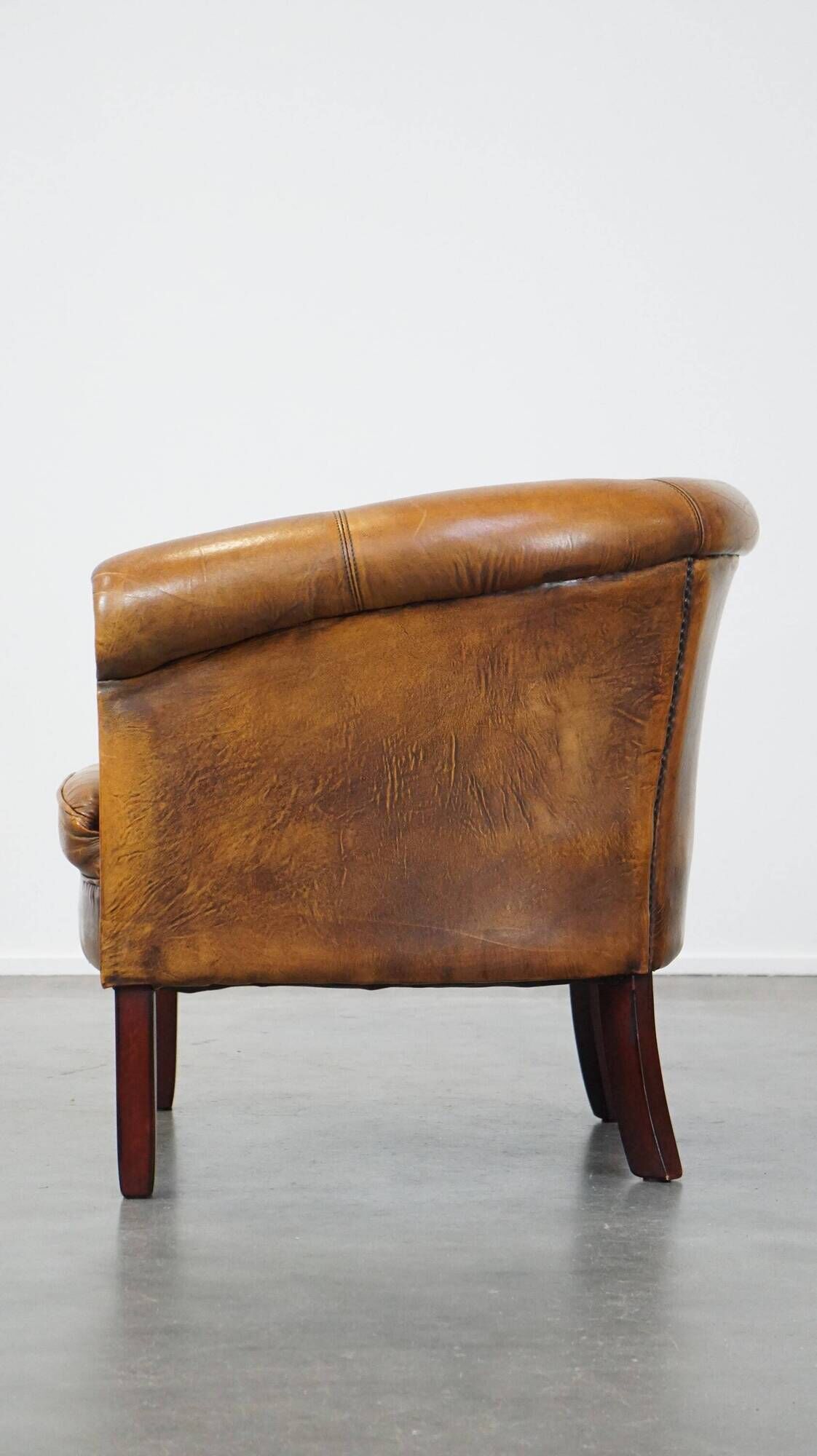 Fauteuil club en peau de mouton subtile avec finition cloutée décorative