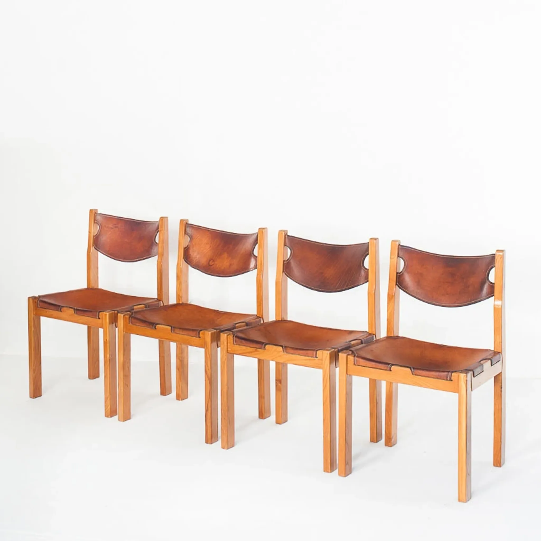 Ensemble de quatre chaises vintage. Bois d'orme et cuir. Maison Regain 70s