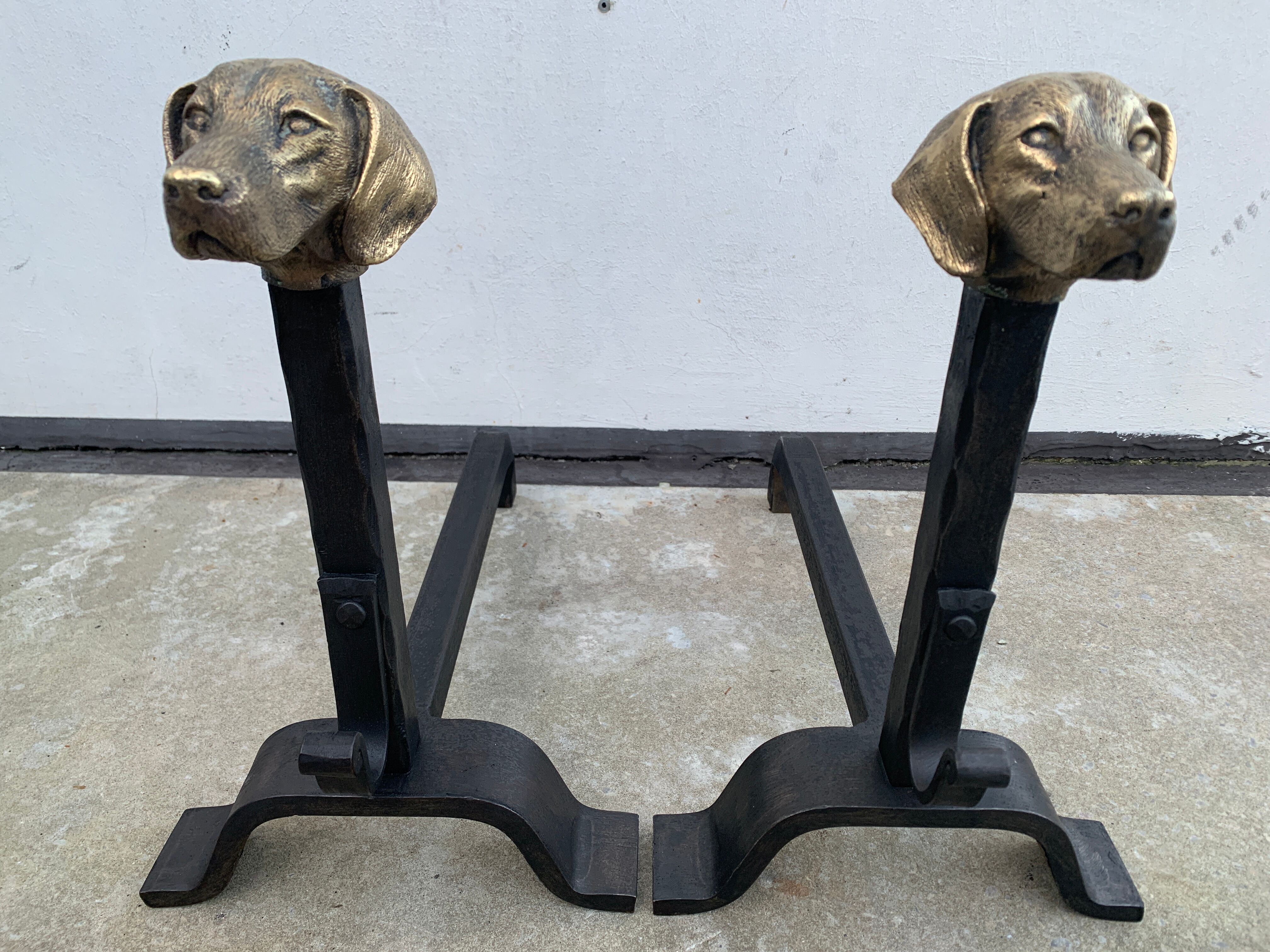 Pair of metal chenets decorated with brass dog heads
