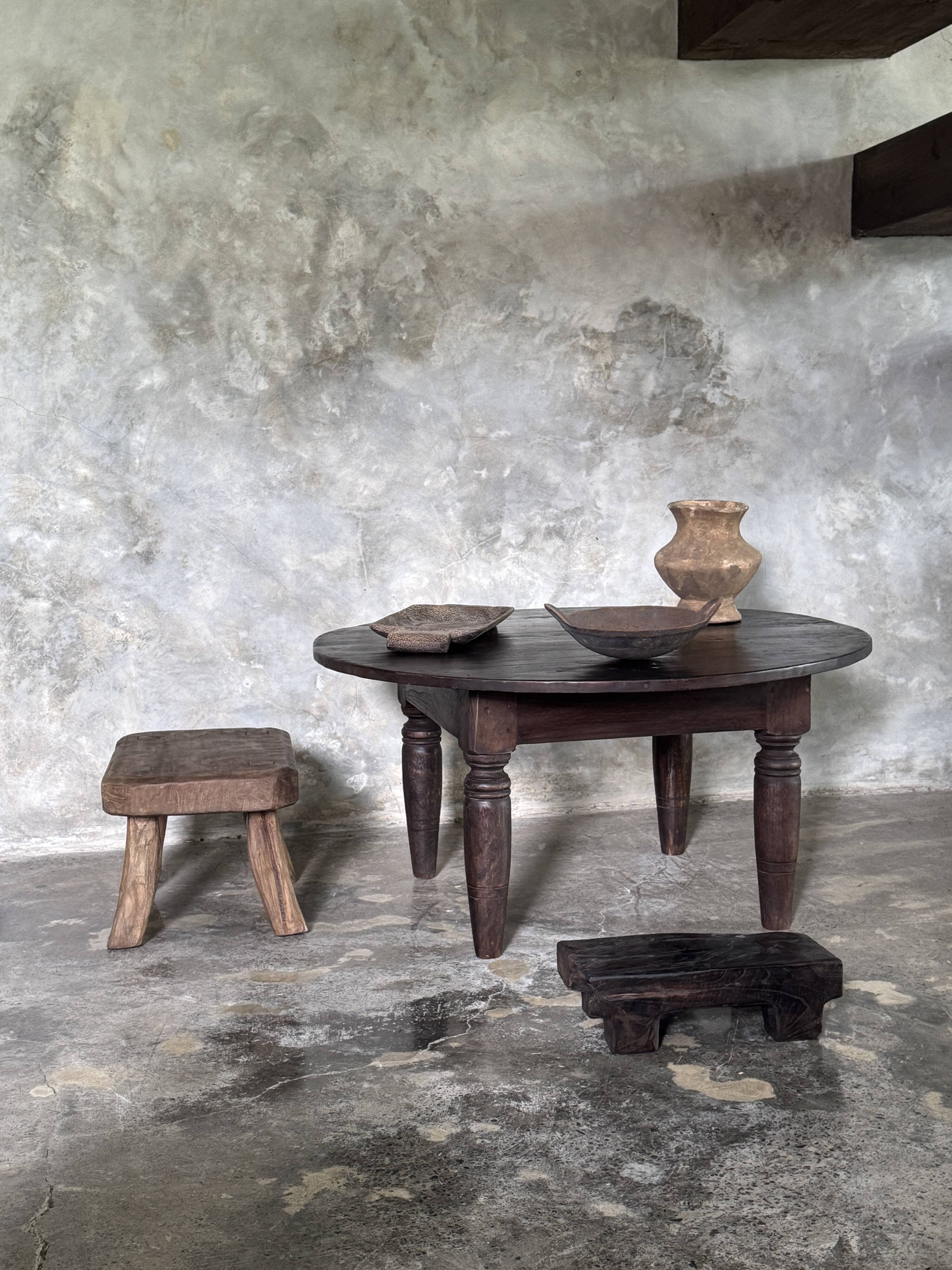 Antique round coffee table in Indonesian teak with turned legs.