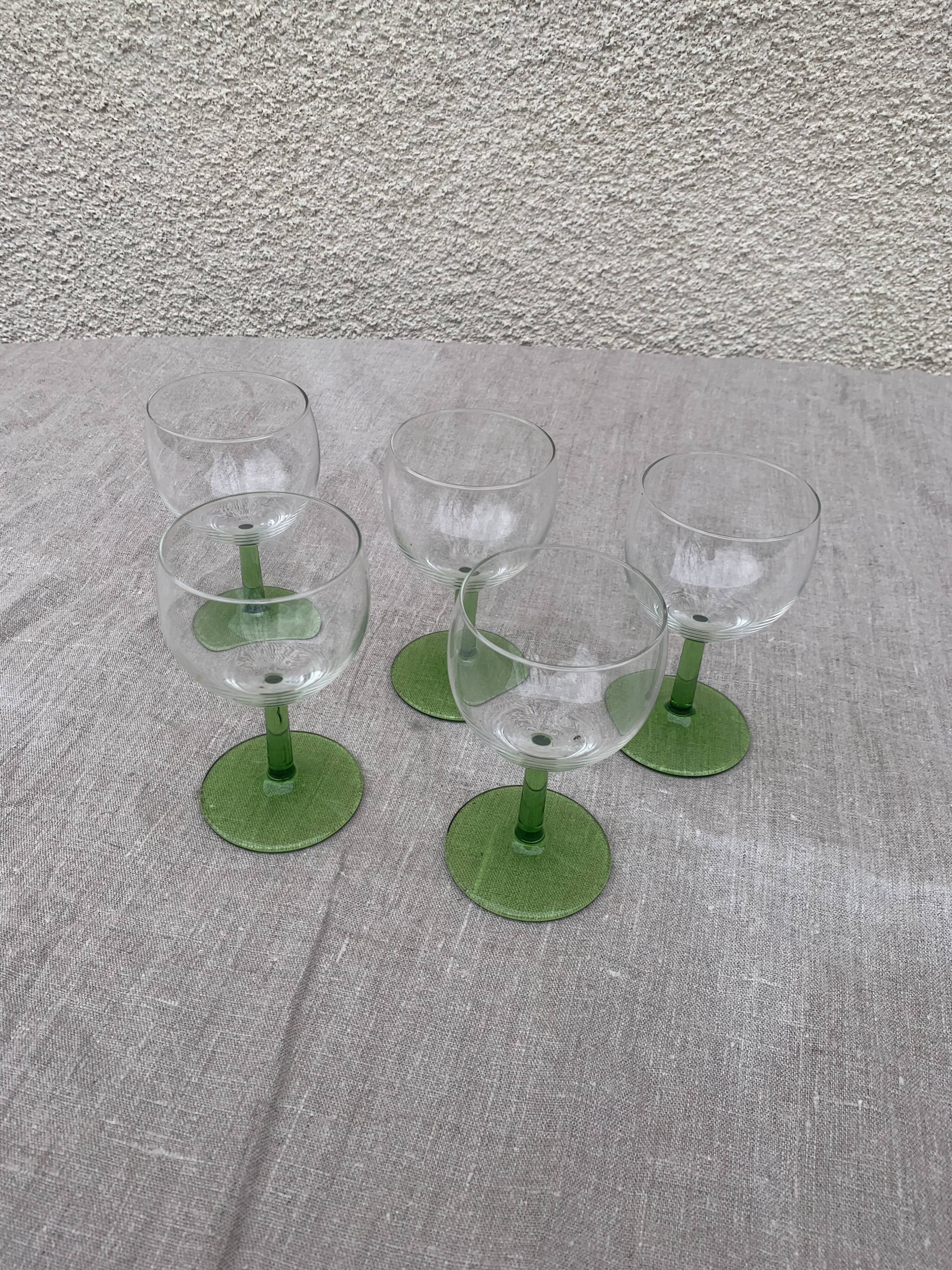 5 transparent glass glasses and green glass vase go