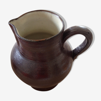 Pitcher has water in glazed stoneware of dark brown color