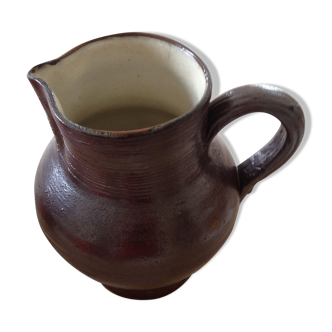 Pitcher has water in glazed stoneware of dark brown color