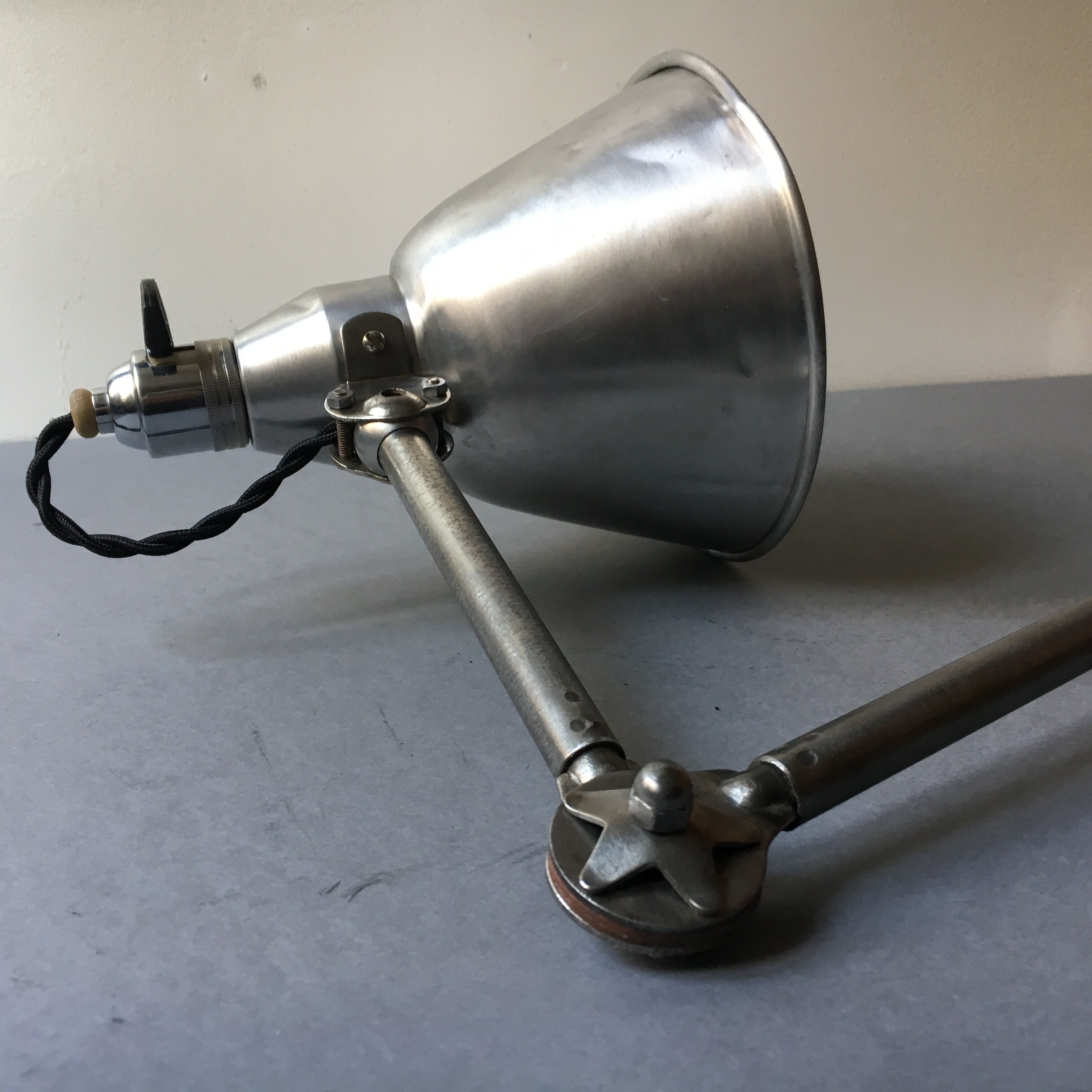 Old industrial lamp has vise 'mazda '.