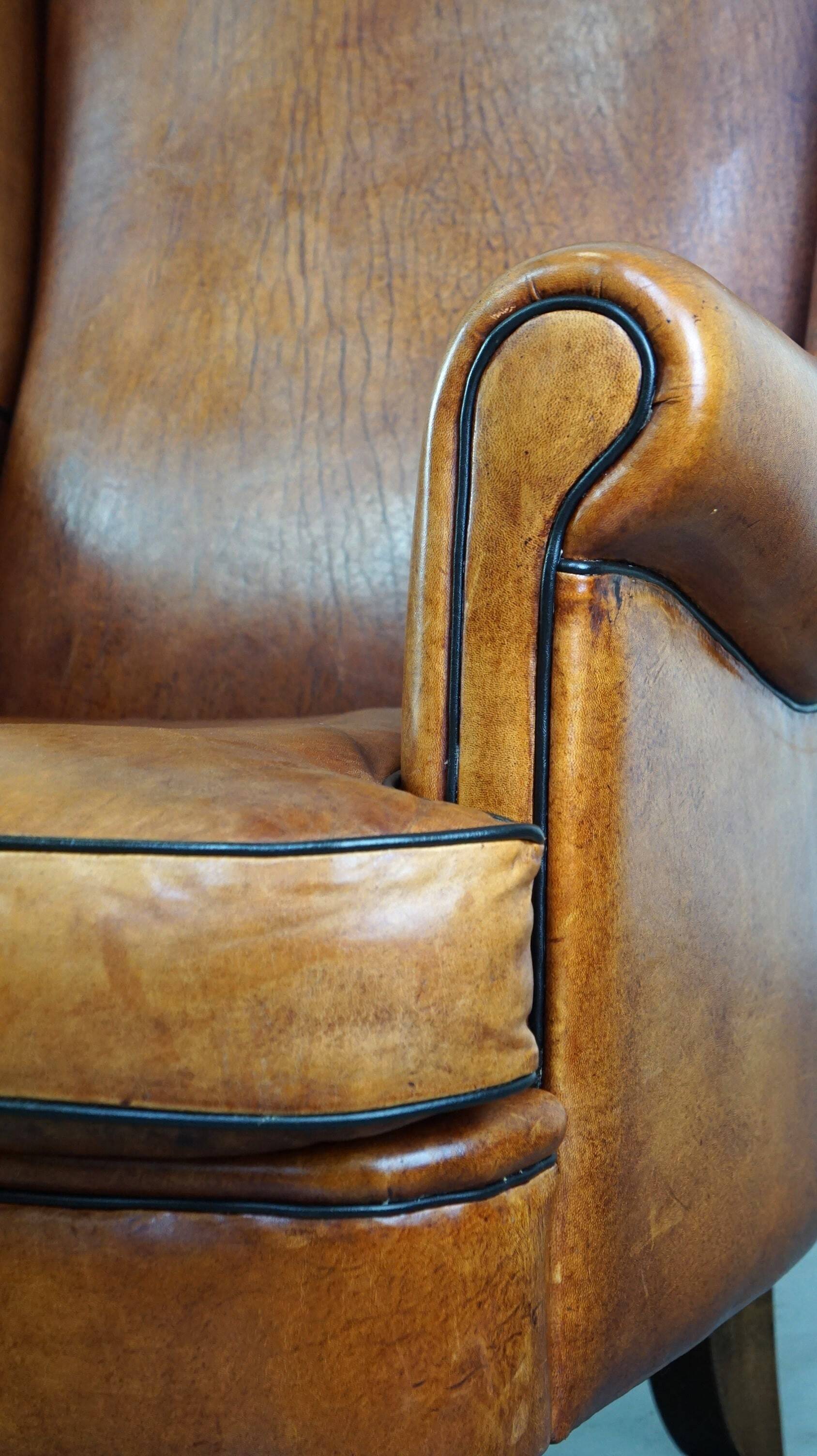 Subtle and well-maintained sheep leather armchair on brass front wheels