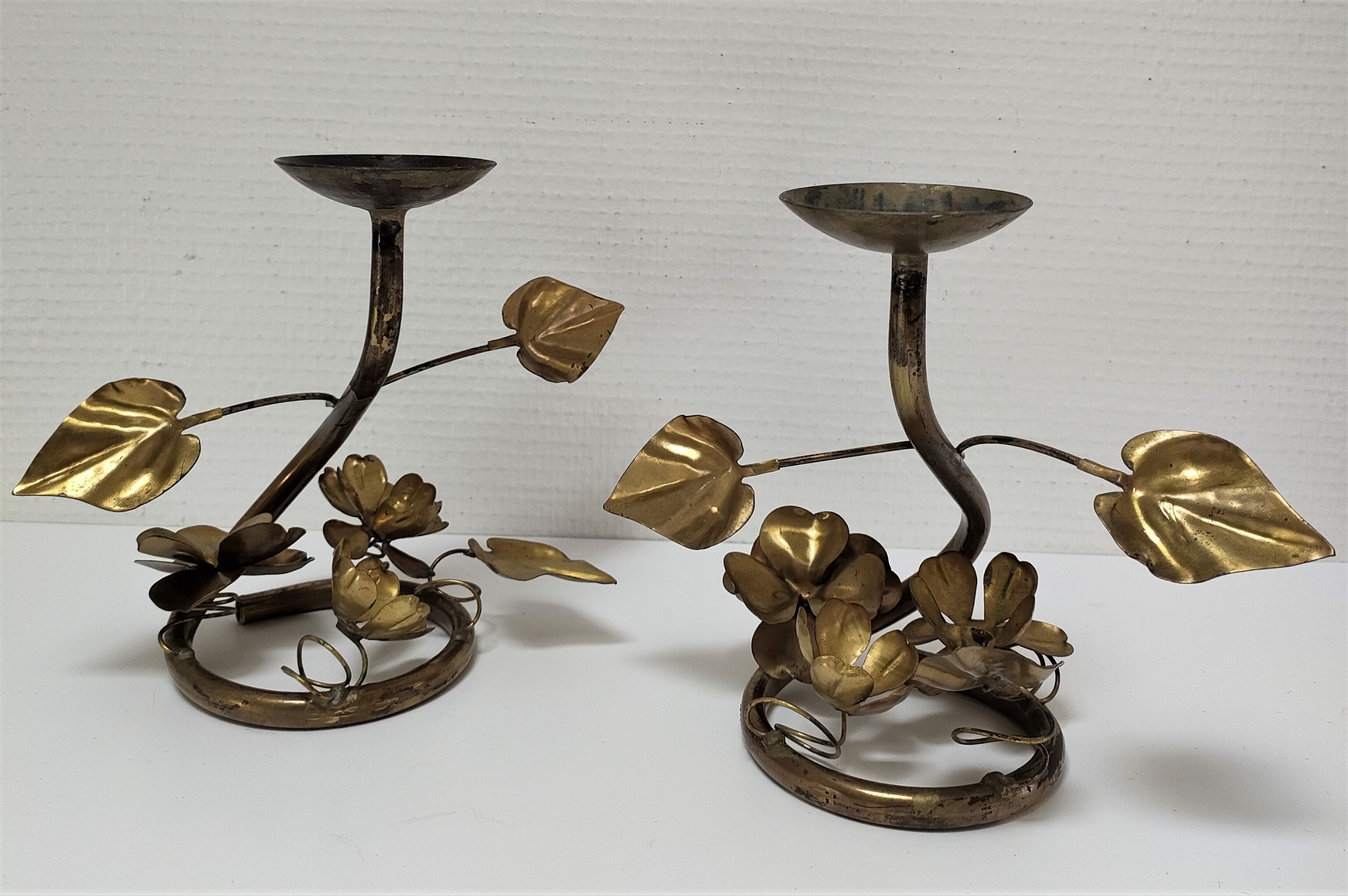Pair of brass candle holders decorated with patinated metal flowers