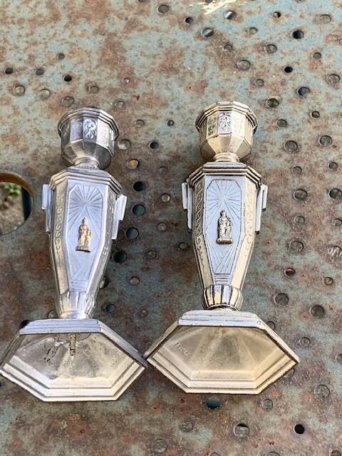 Pair of metal candlesticks, chiseled with a statuette in front, rose pattern in relief, art deco