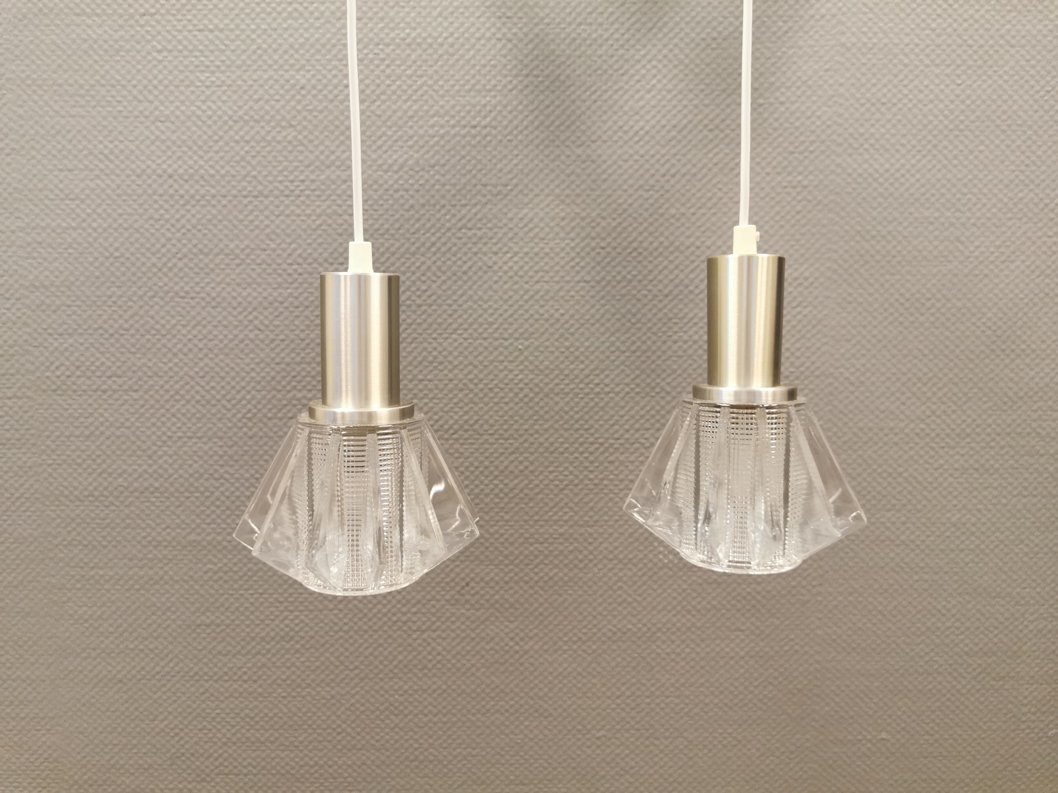 A set of smaller hanging lamps, in hard pressed glass, with metal top