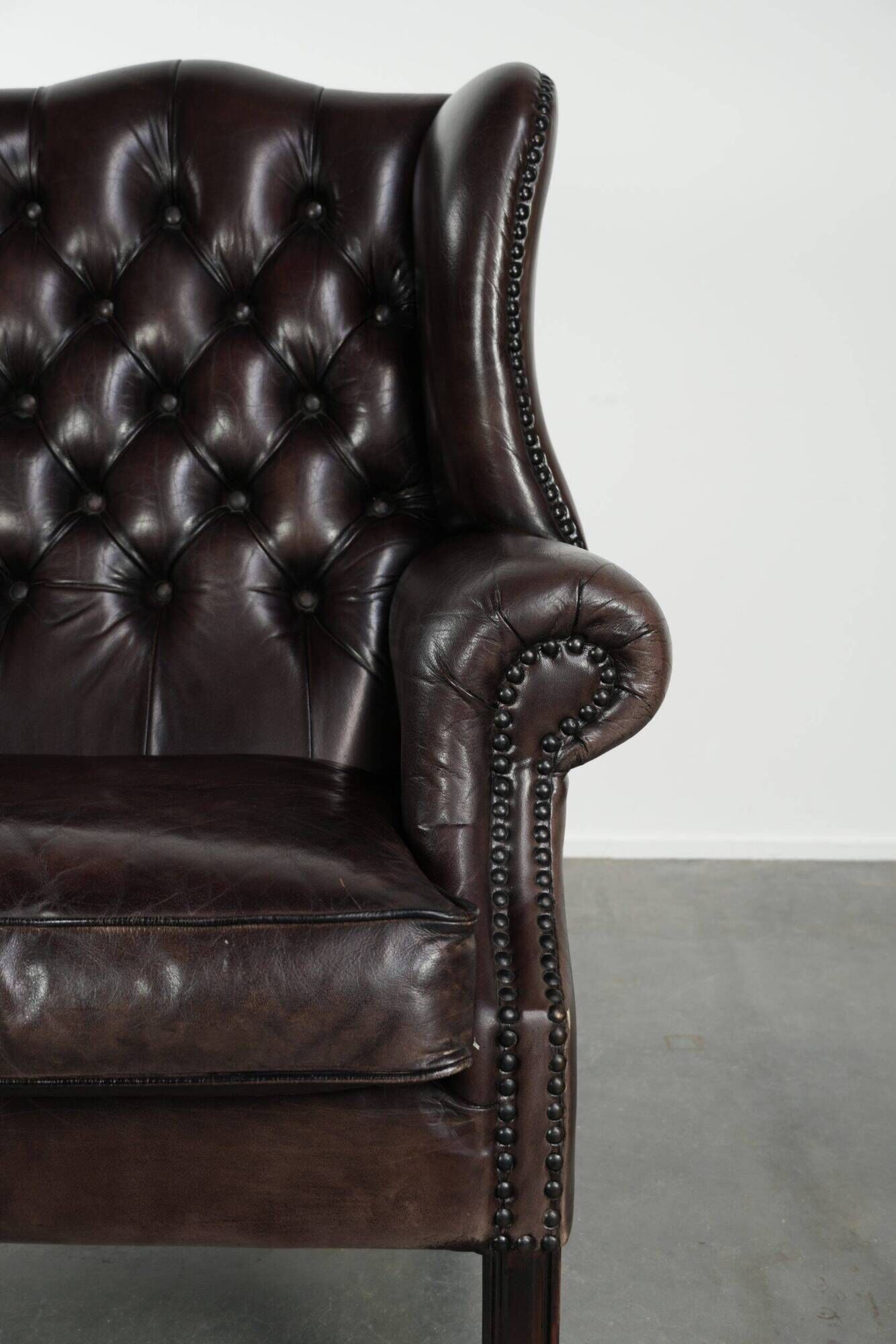 Dark brown cowhide Chesterfield wingback armchair in classic English style