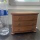 Blonde wooden doll's chest with brass handles.