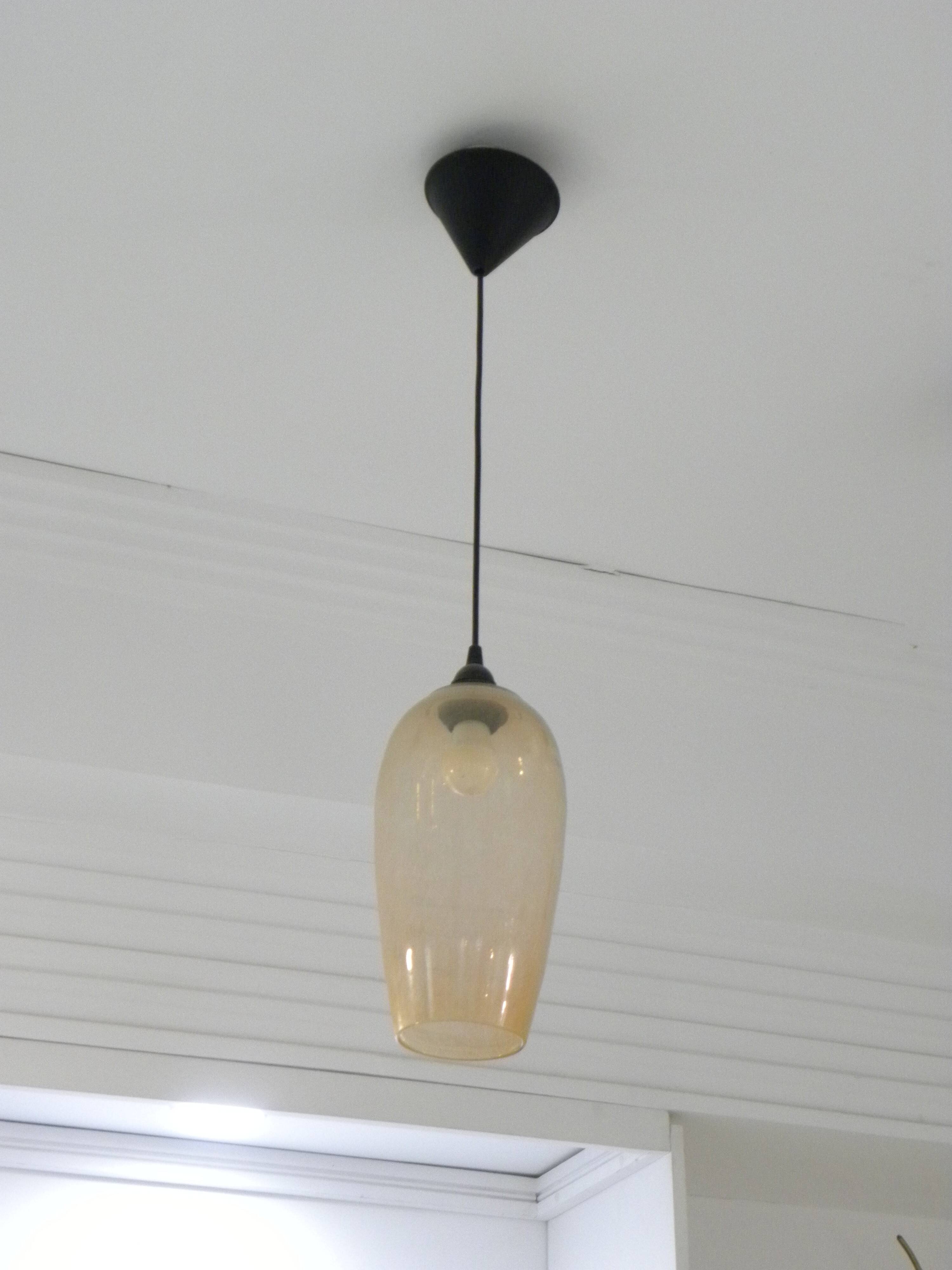 Amber glass suspension light, warm modern interior lighting.