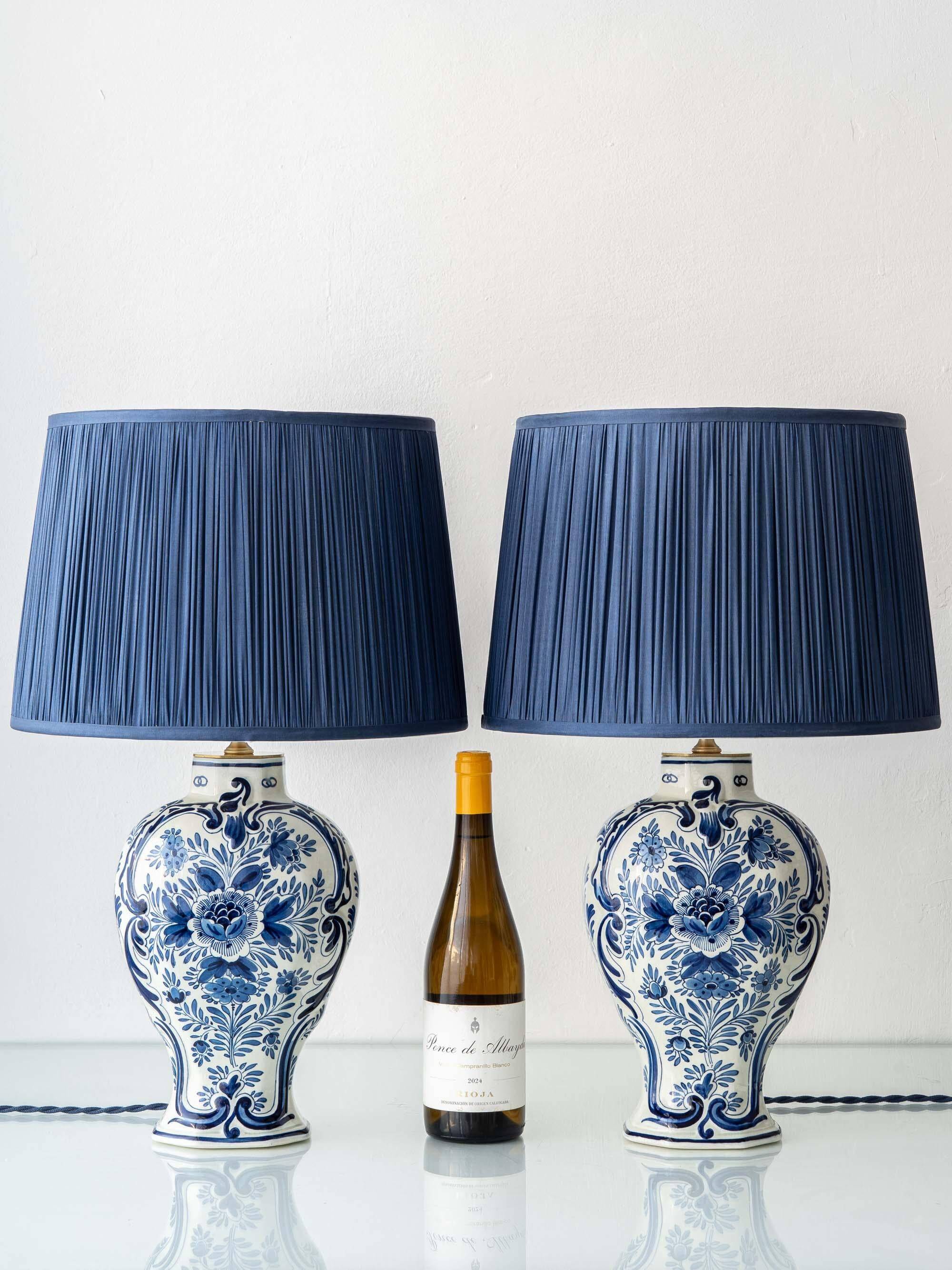 Pair of Royal Delft blue and white ceramic table lamps, 1905, with new pleated silk shades.
