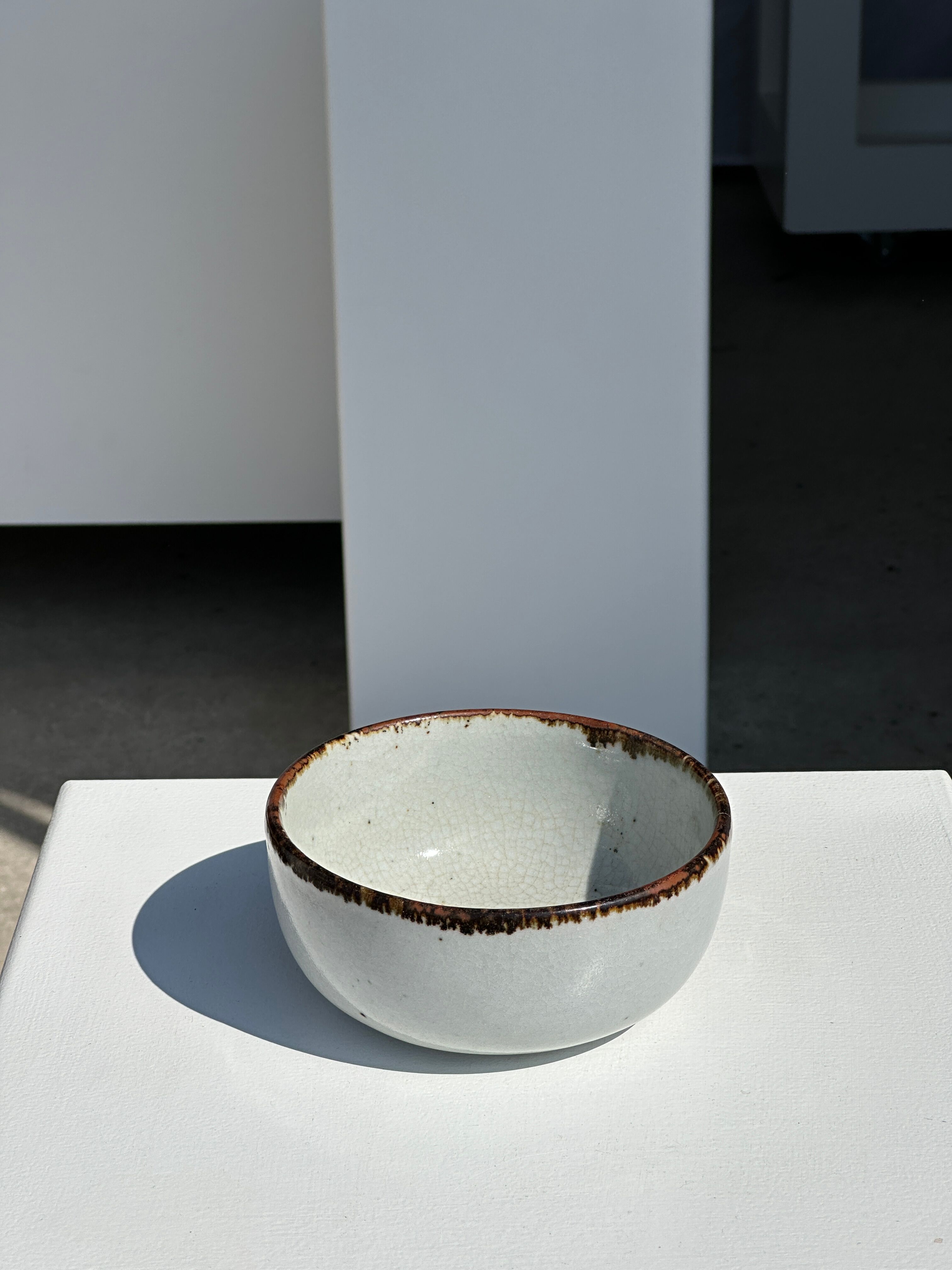 Small white glazed ceramic bowl black edges
