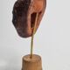 Expressive sculpted head in patinated terracotta on wooden base, 14 cm