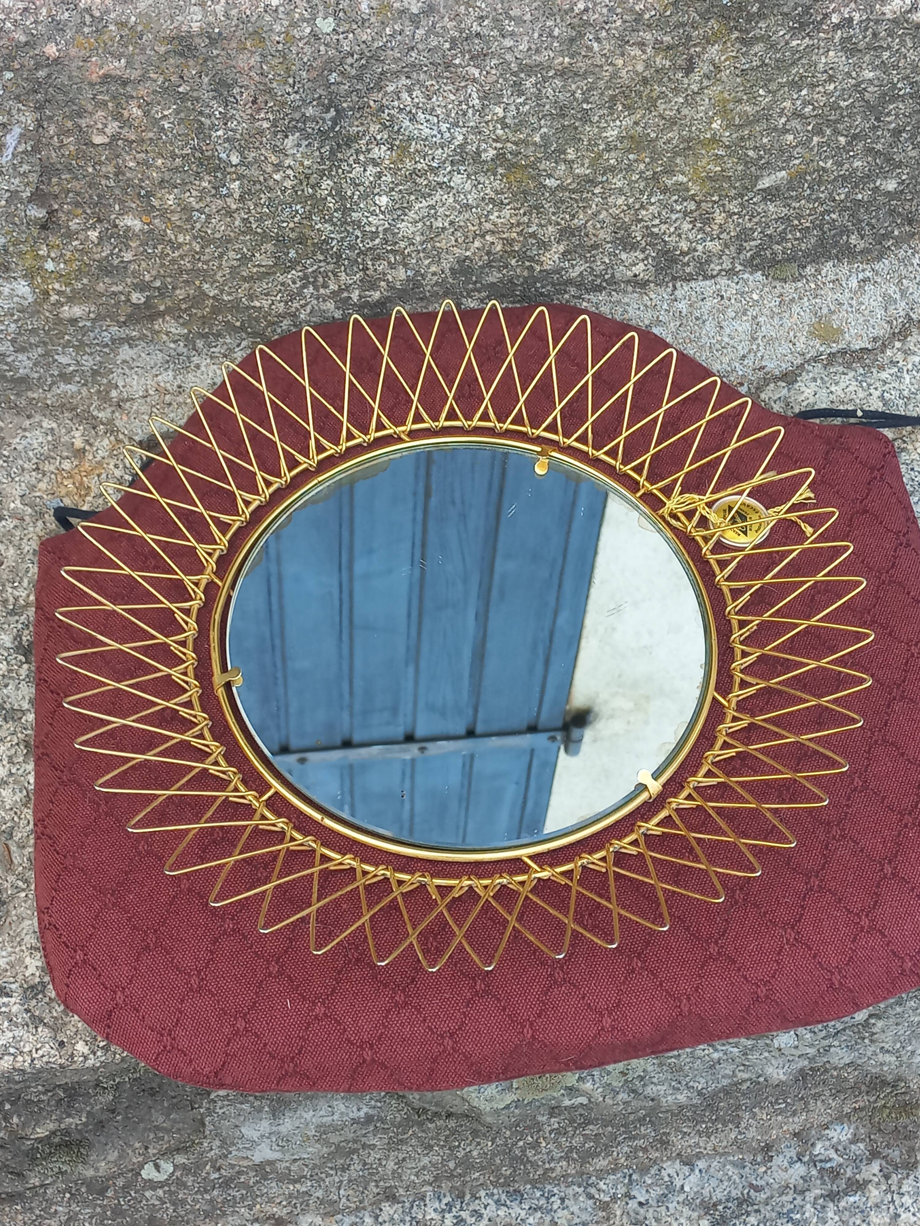 Vintage 1950s sun mirror in gold metal.