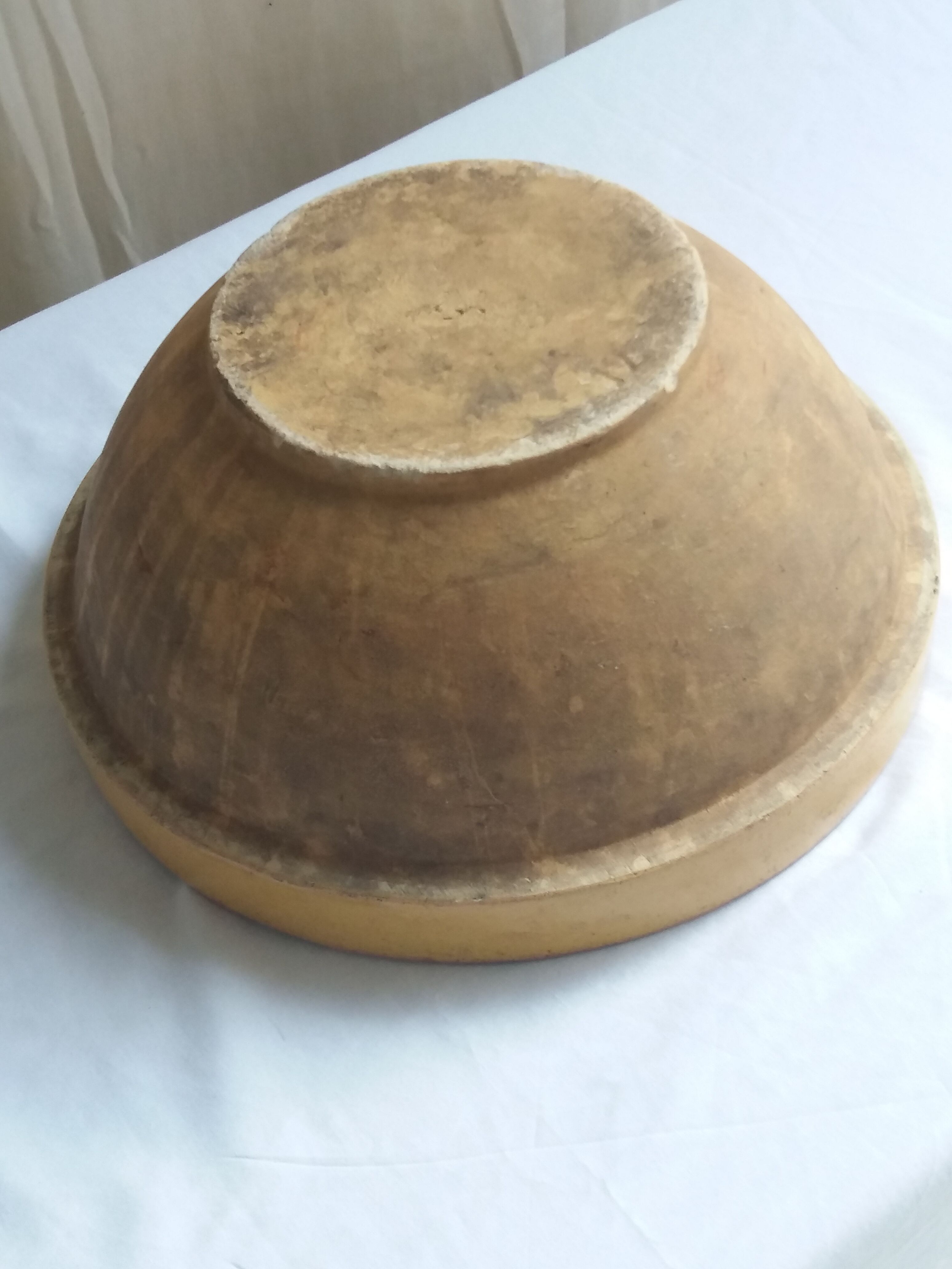 Large old salad bowl in yellow varnished earth