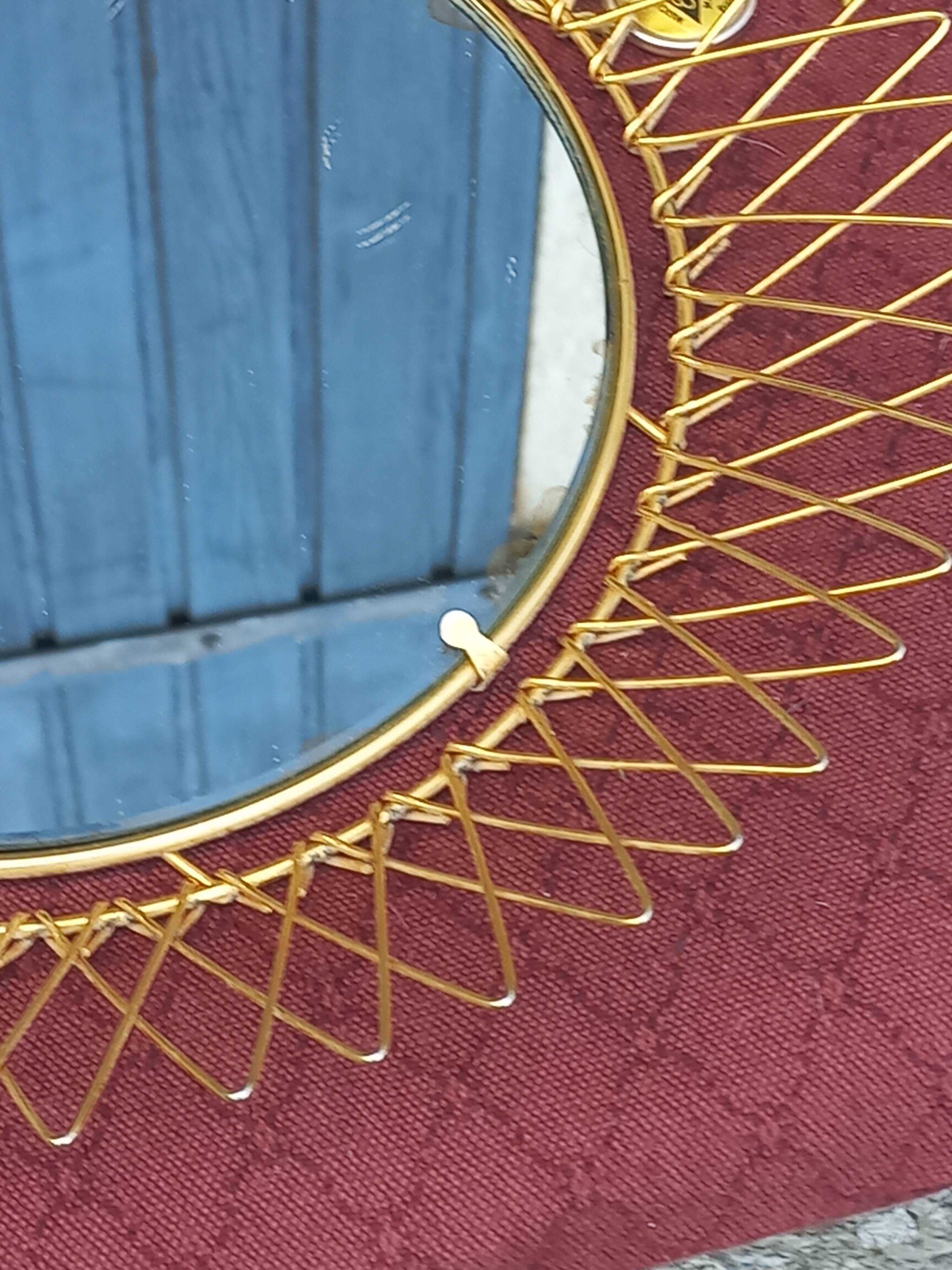 Vintage 1950s sun mirror in gold metal.