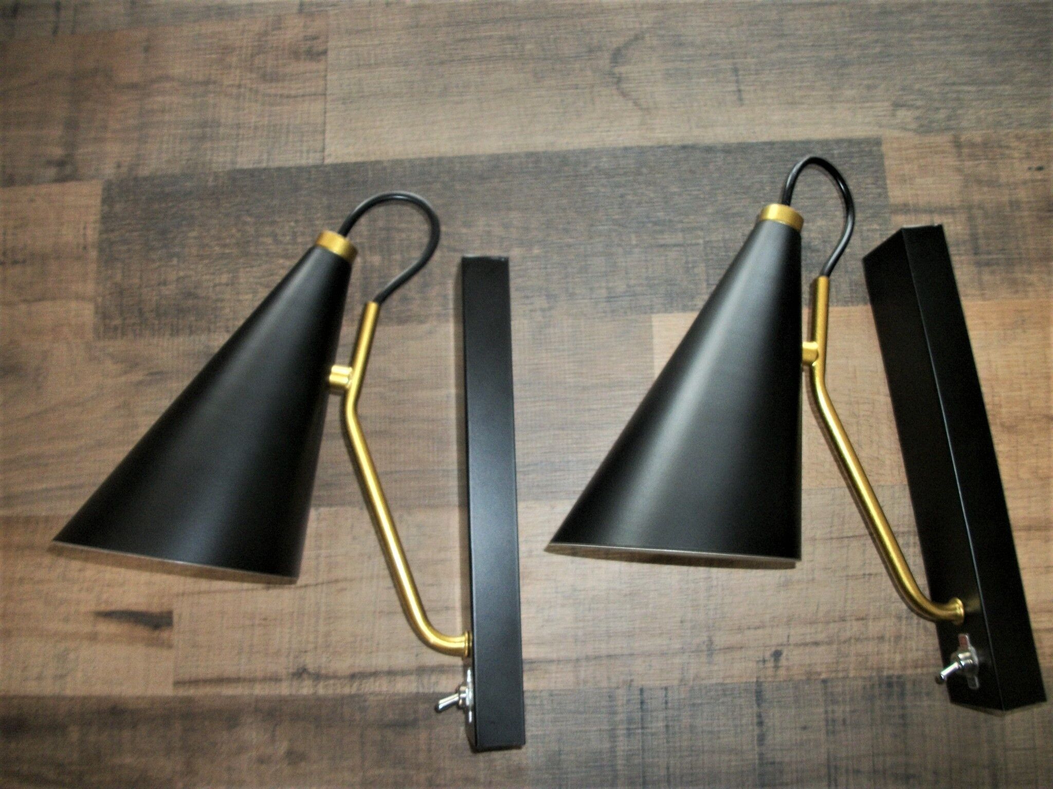Pair of modernist sconces in black and gold metal