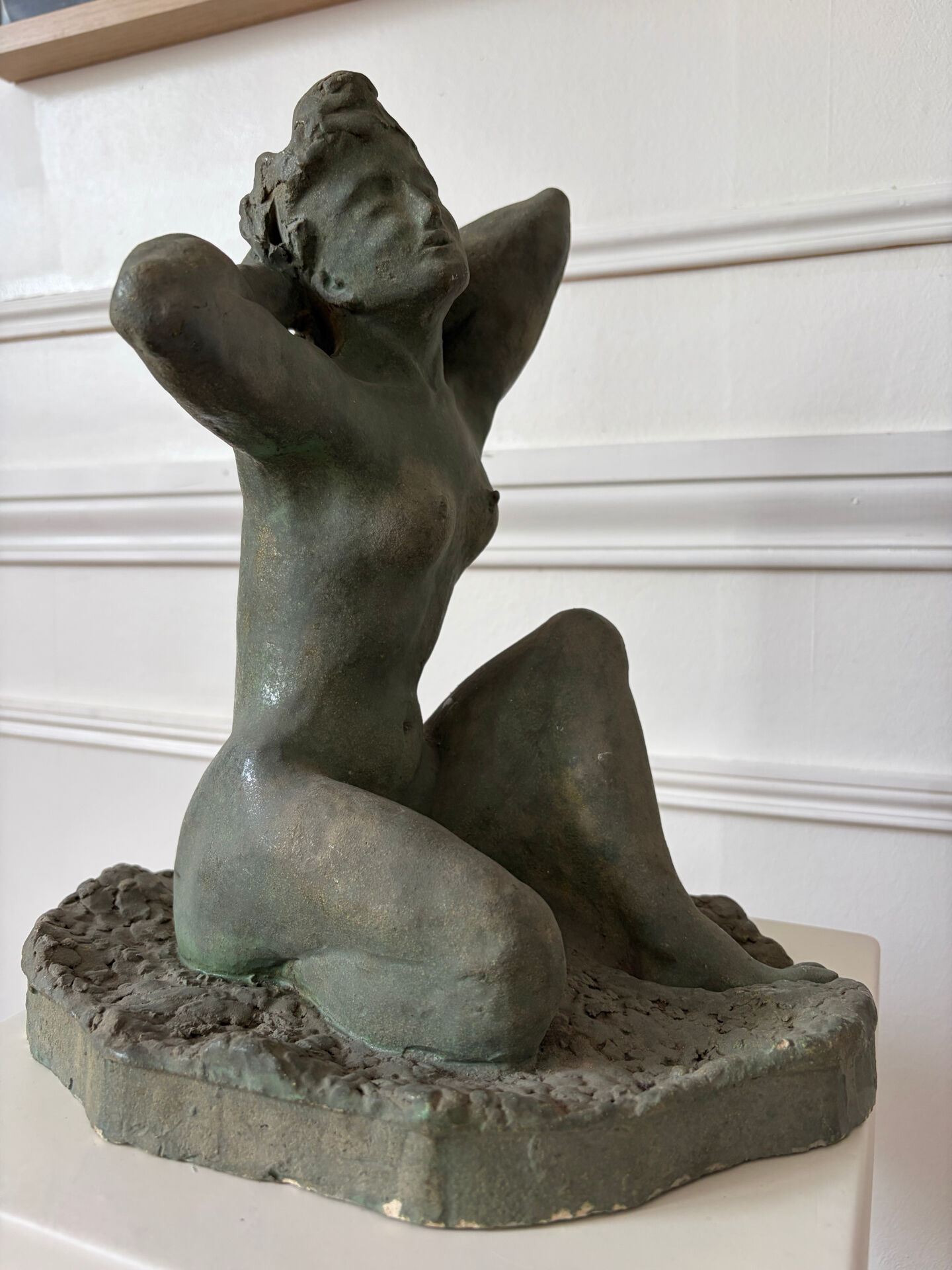 Sculpture of a naked woman titled "Youth" in terracotta.