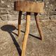 Rustic three-legged stool in minimalist wood in the style of Touret.