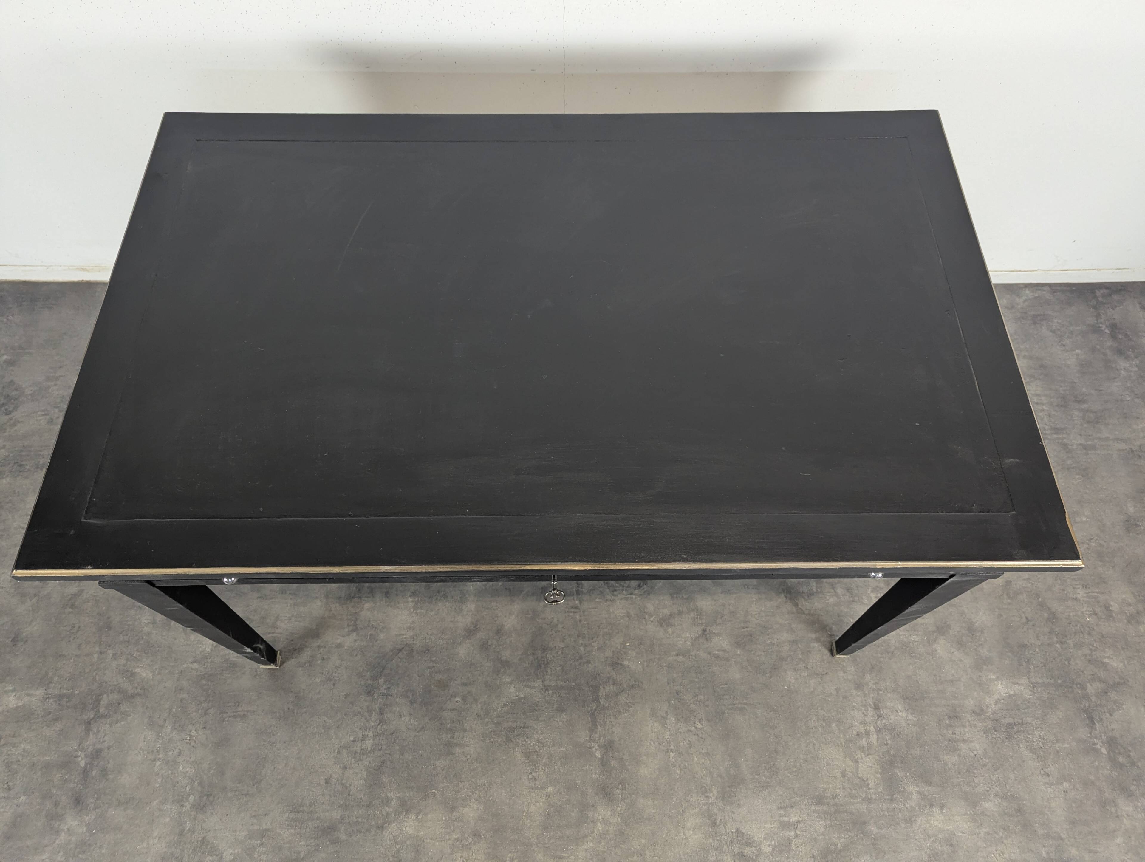 Large flat desk in Louis XVI style, black lacquered with gold highlights.