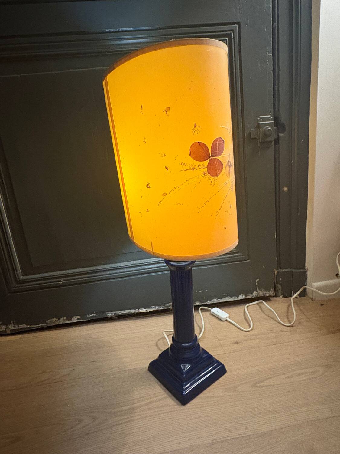 Corinthian column lamp base in blue with a lampshade of dried flowers.