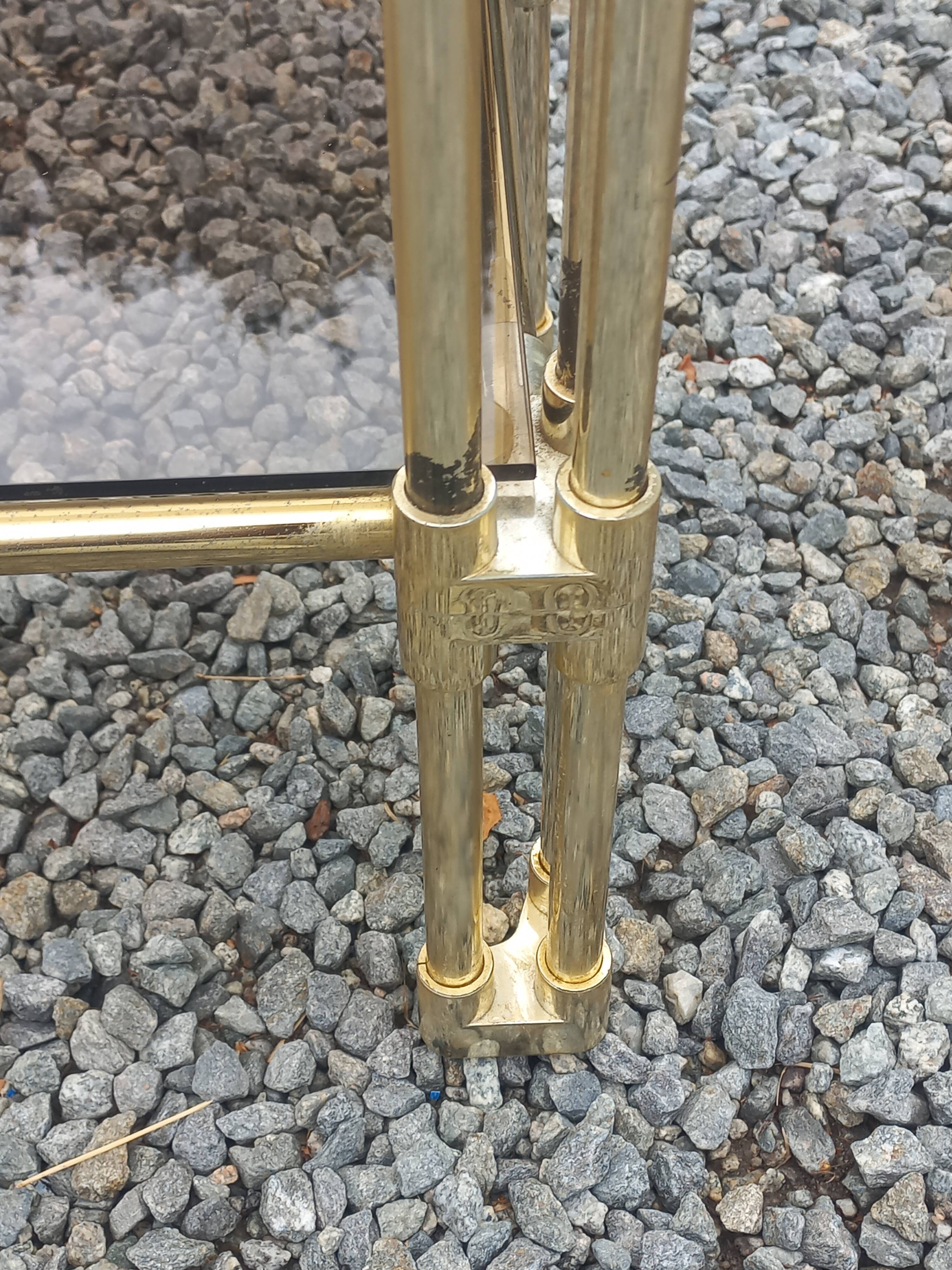 Pair of Hollywood Regency side tables in gold metal and smoked glass.