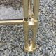 Pair of Hollywood Regency side tables in gold metal and smoked glass.