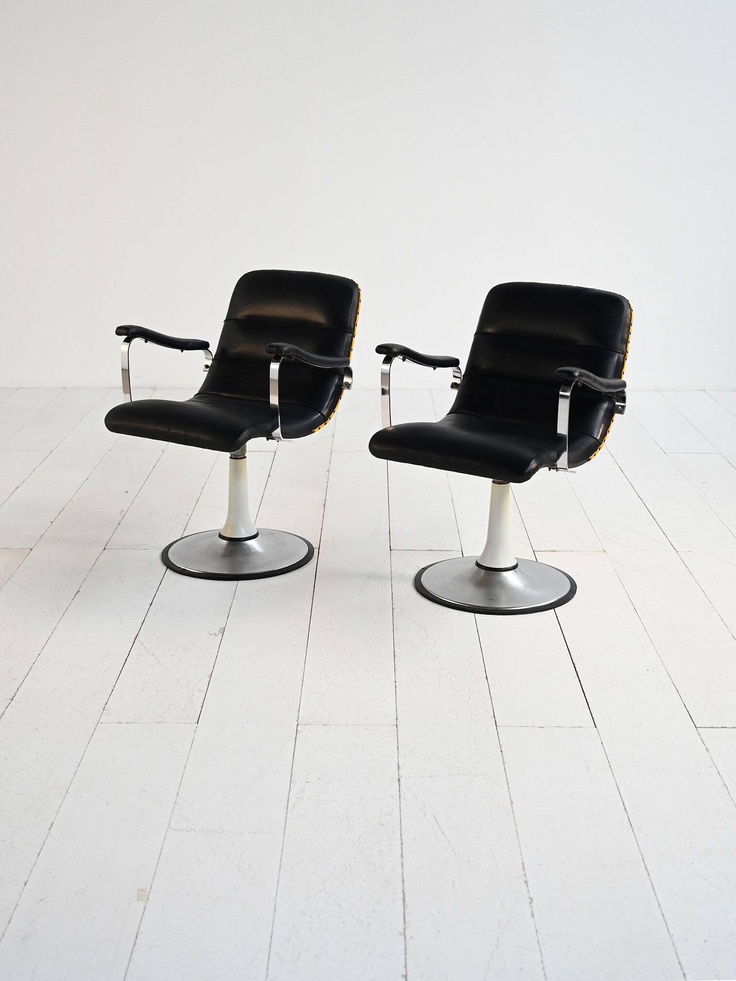 Pair of European 1970s swivel armchairs in faux leather and steel