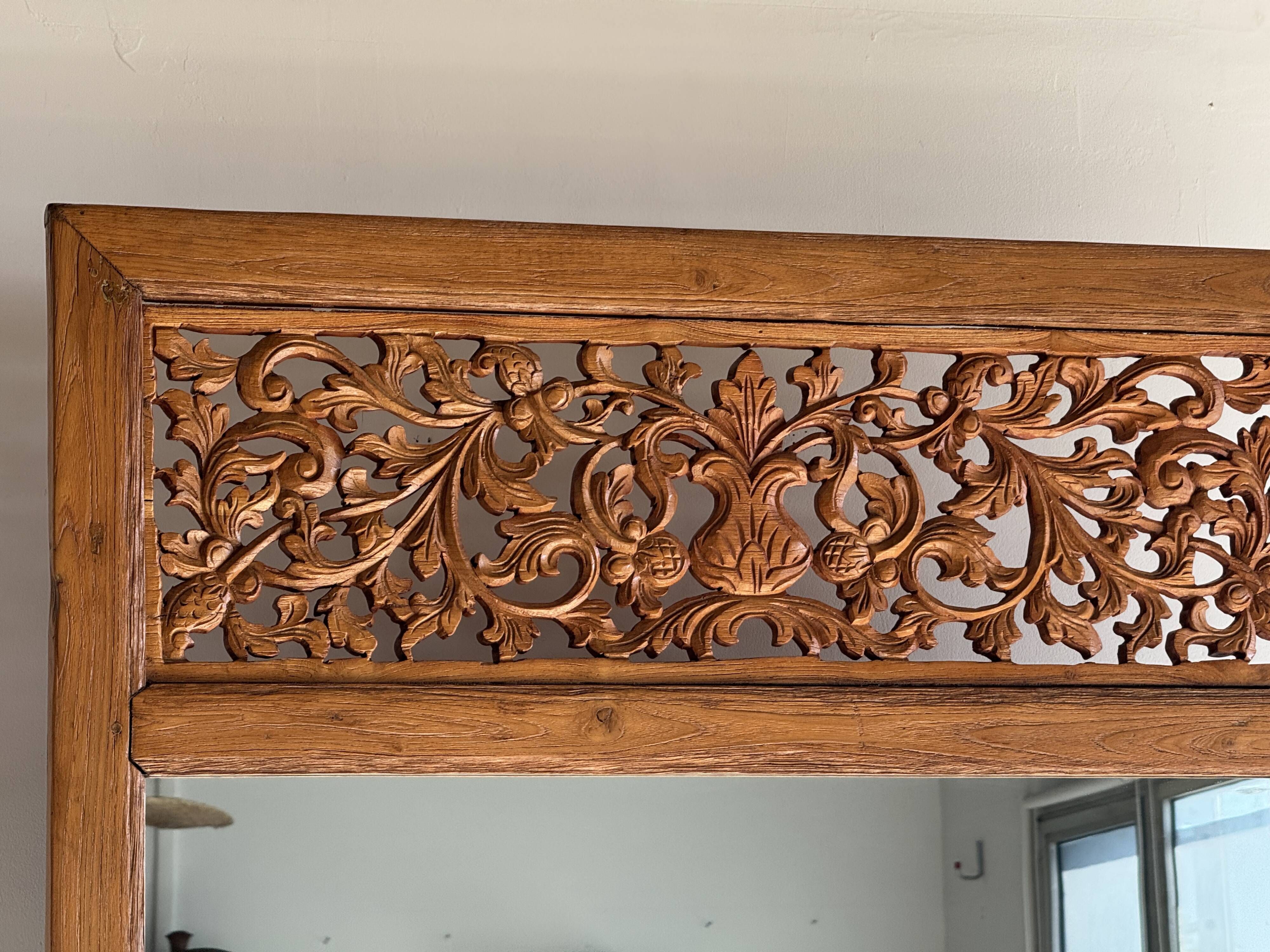Very large freestanding teak mirror with an openwork carved pediment, Indonesia.