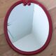 Oval mirror, red enamelled metal in Art Deco style, 49 x 39 cm.