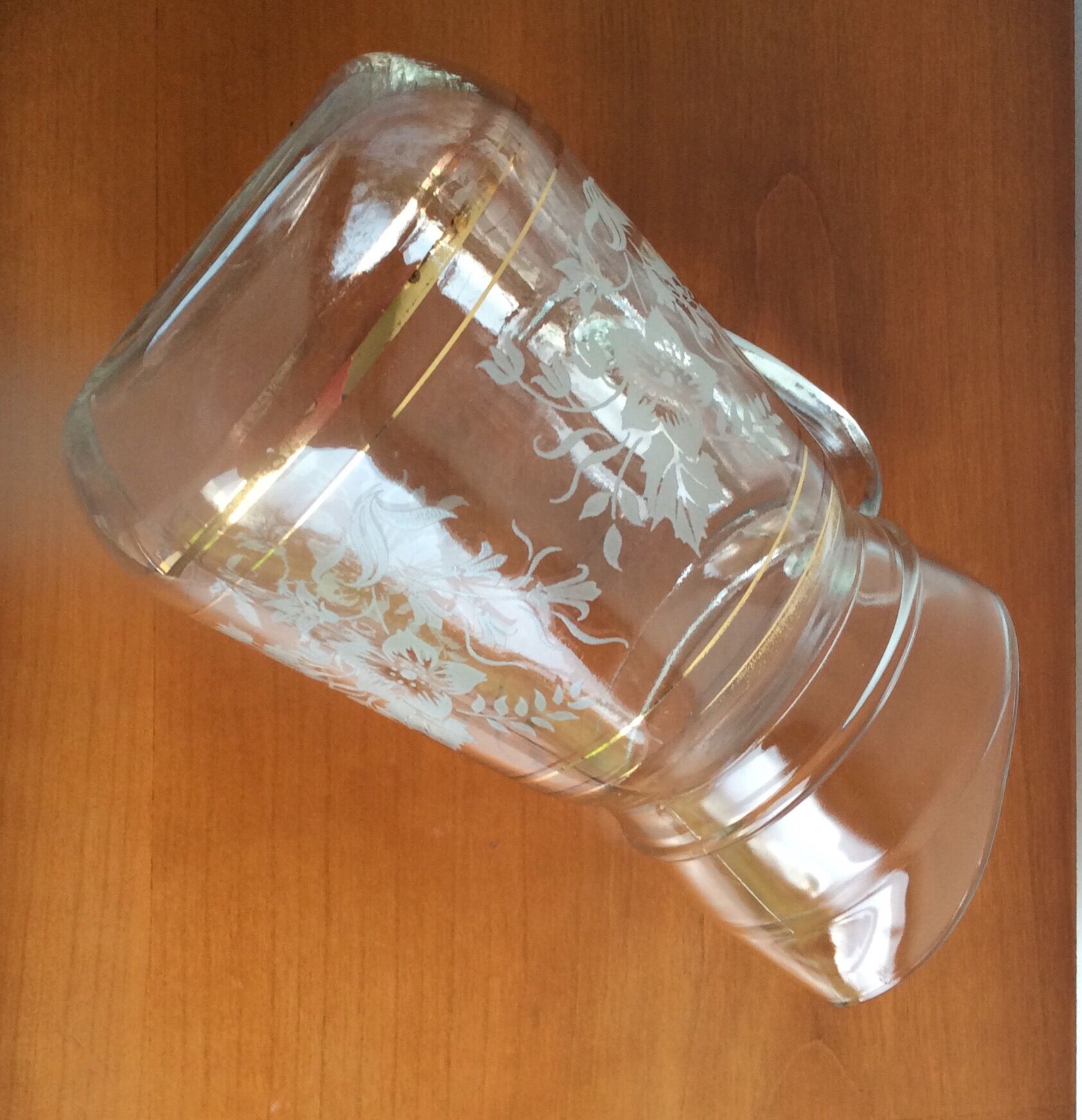 Old glass water pitcher with white flowers in relief with gold edging