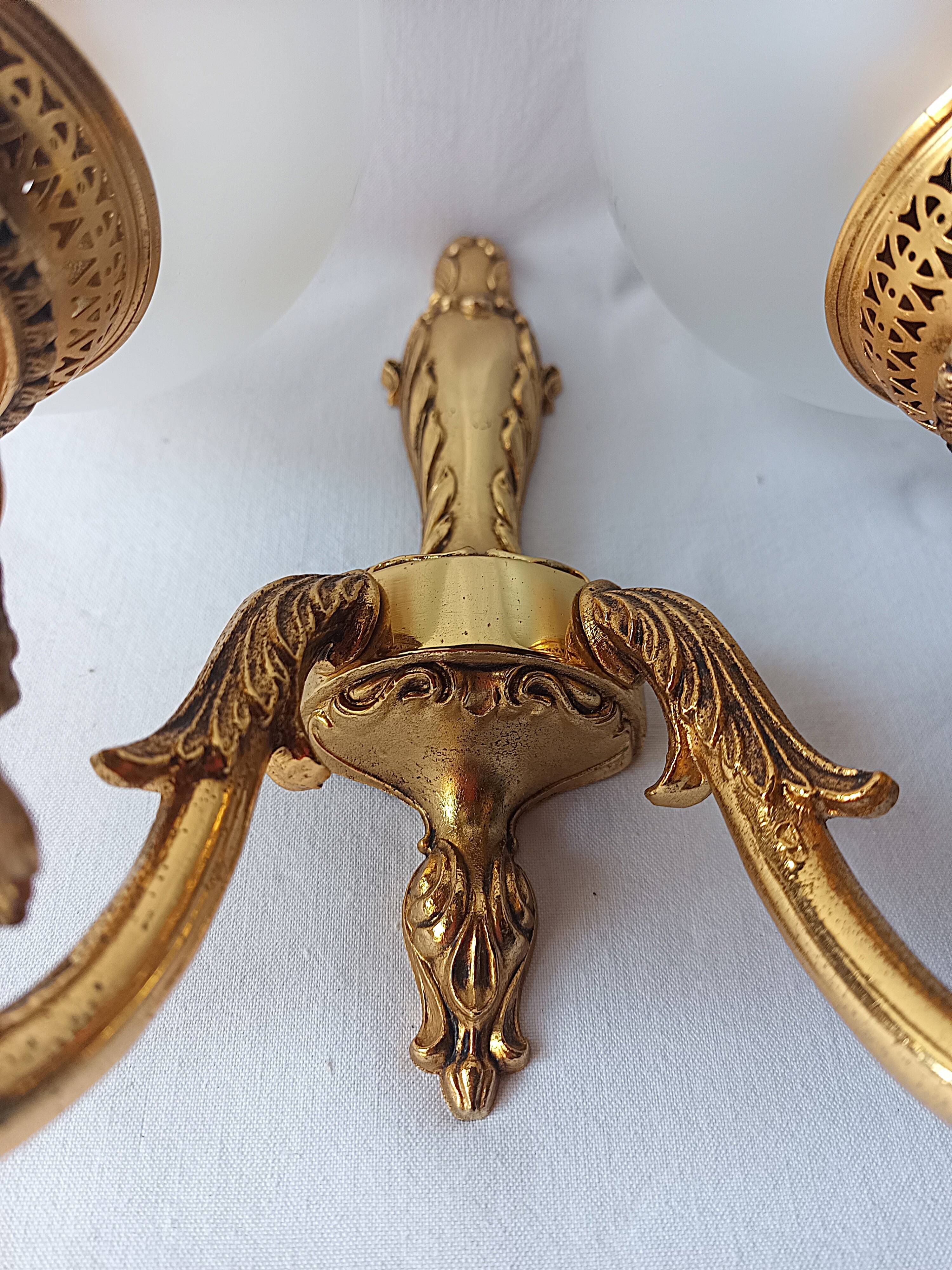 Wall lamp in gilded bronze with a lion's head and engraved globe.