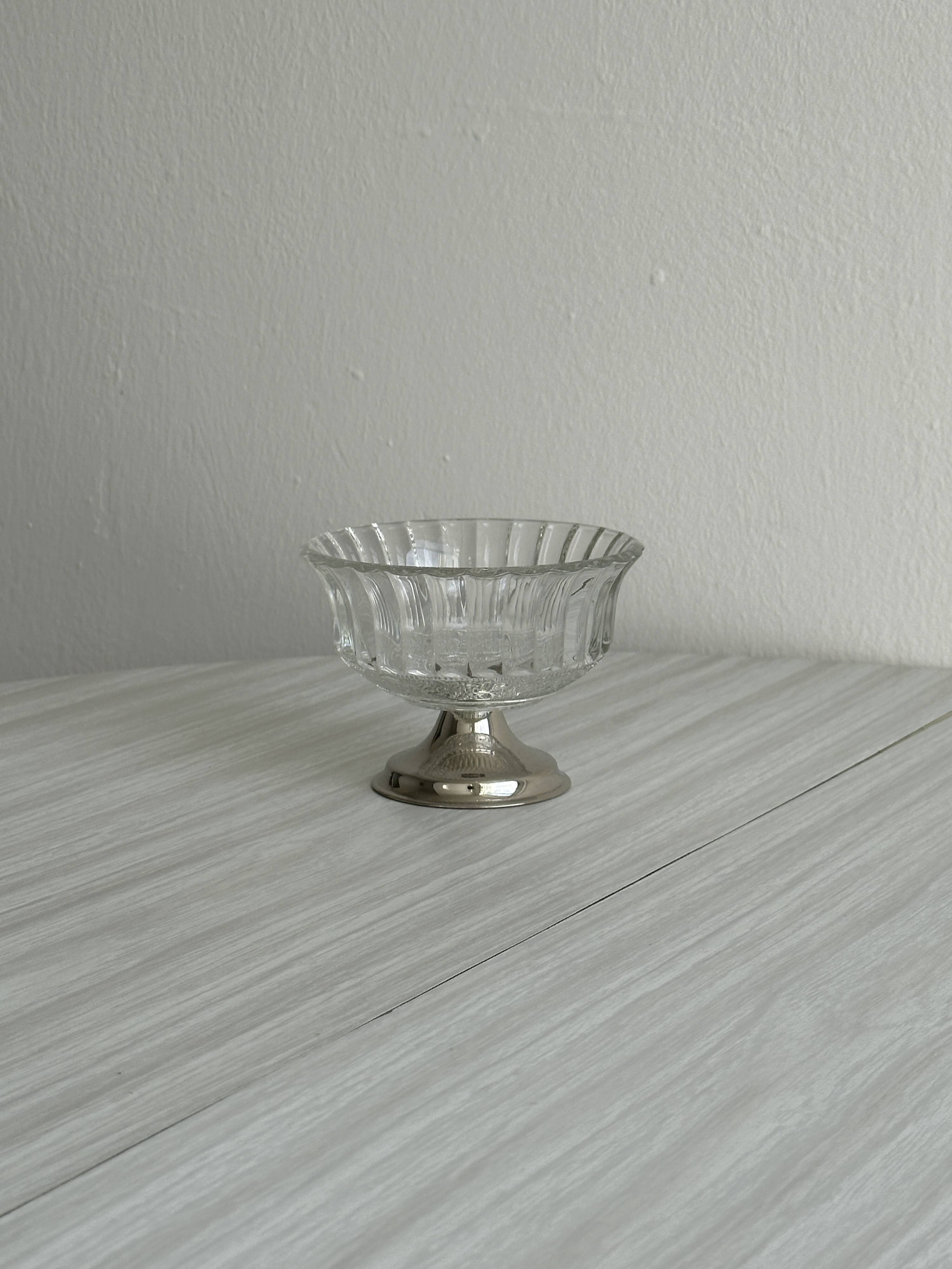 Thick glass bowl on a metal stand.