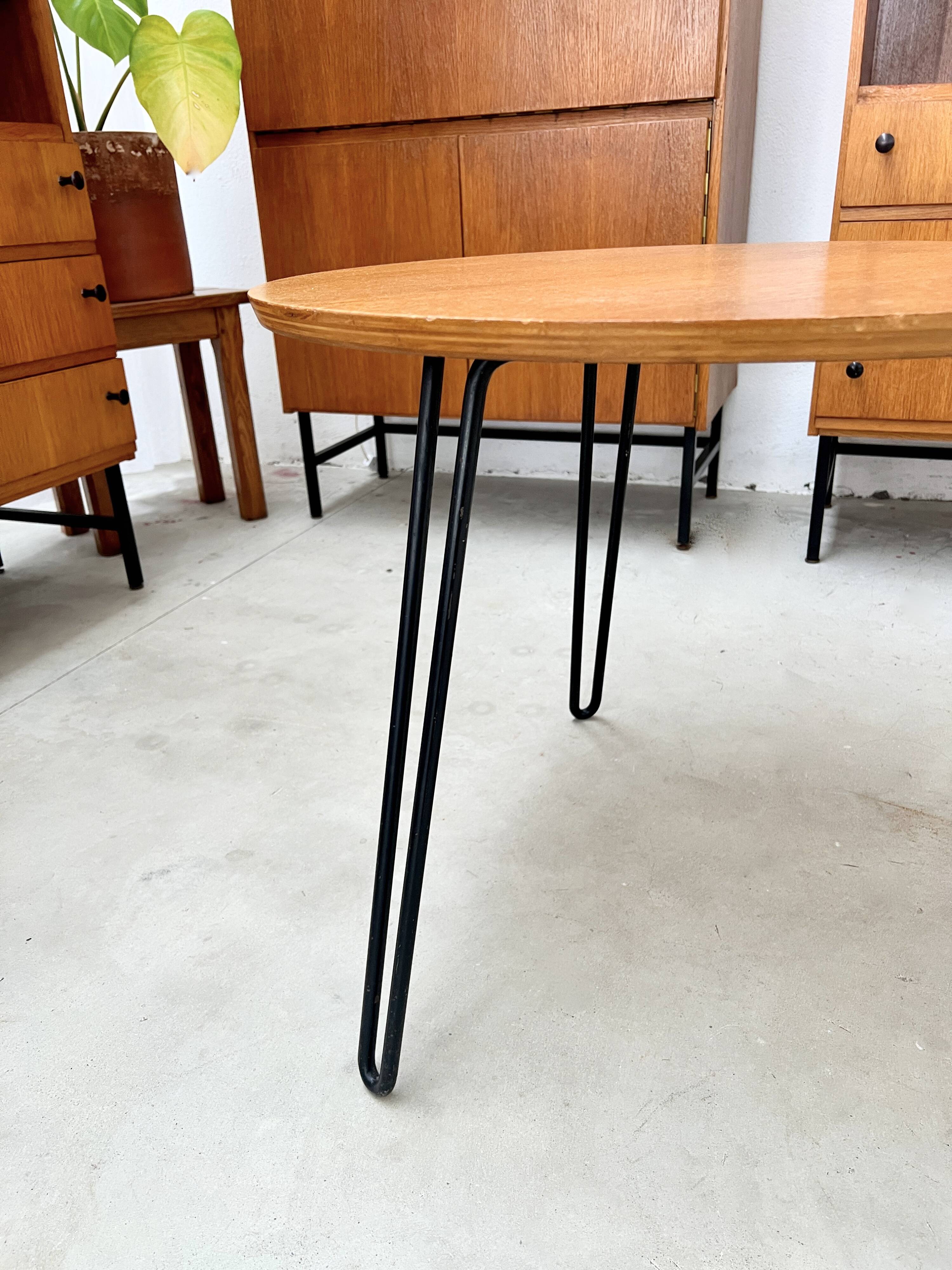 Round side table with black lacquered metal hairpin legs.