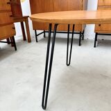 Round side table with black lacquered metal hairpin legs.