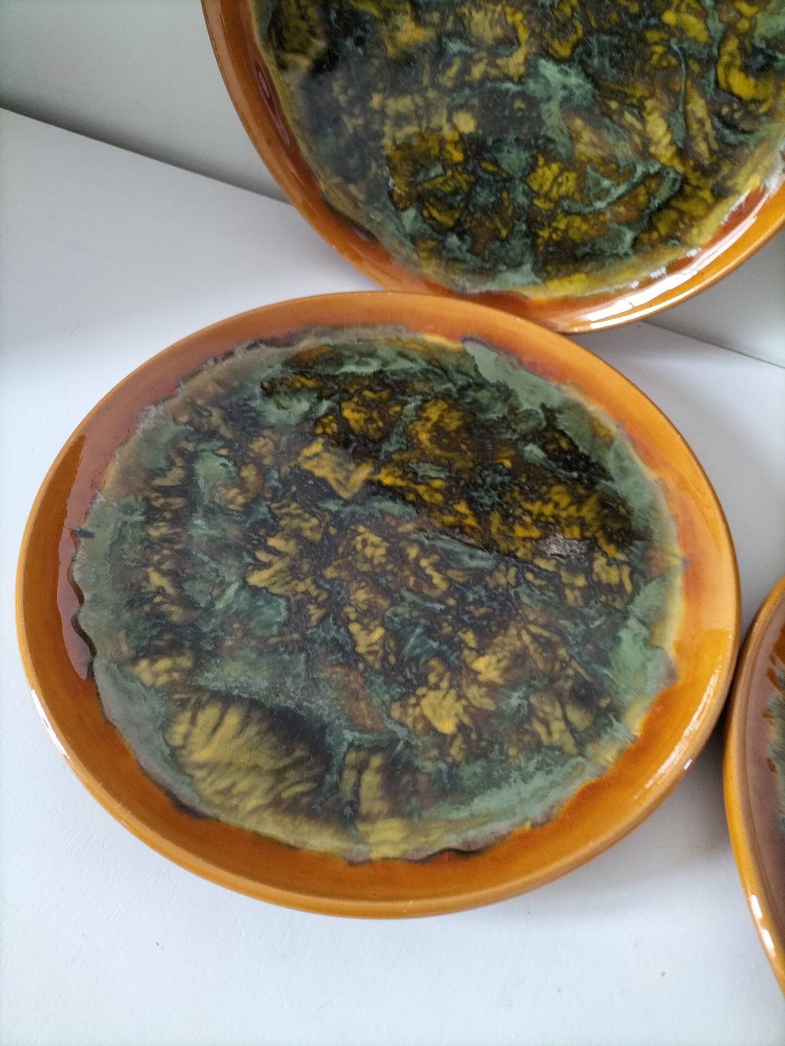 Set of 4 flamed enamel plates in green and amber from the 60s-70s.