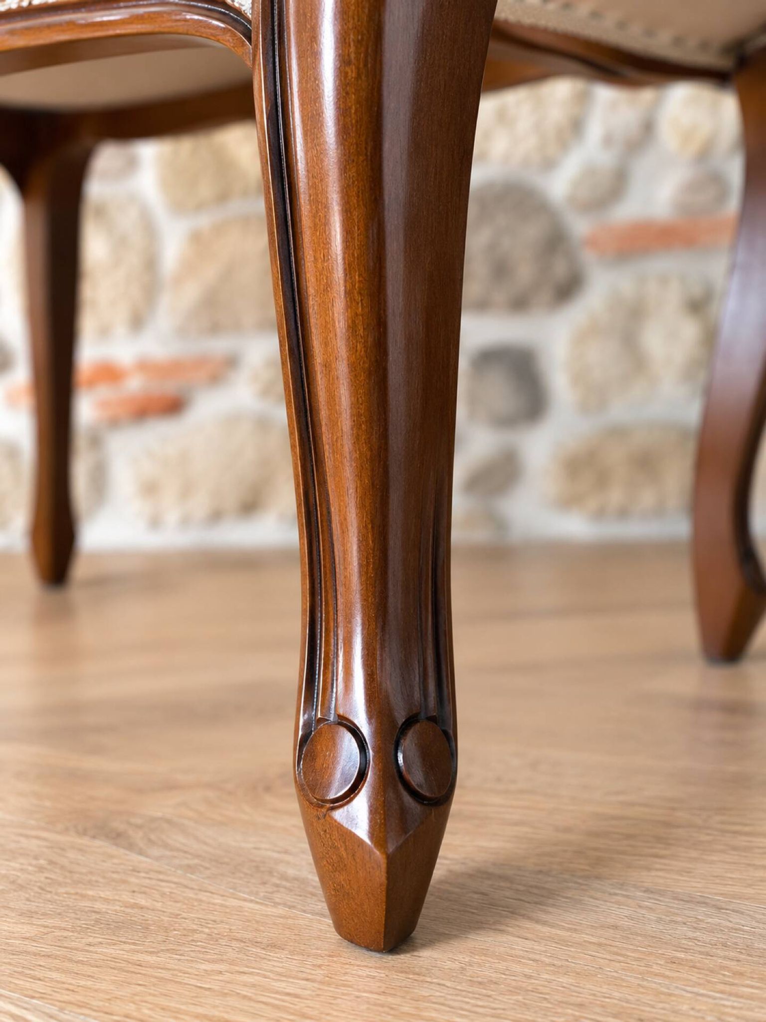 Two-seater bench in carved wood, with curved armrests.