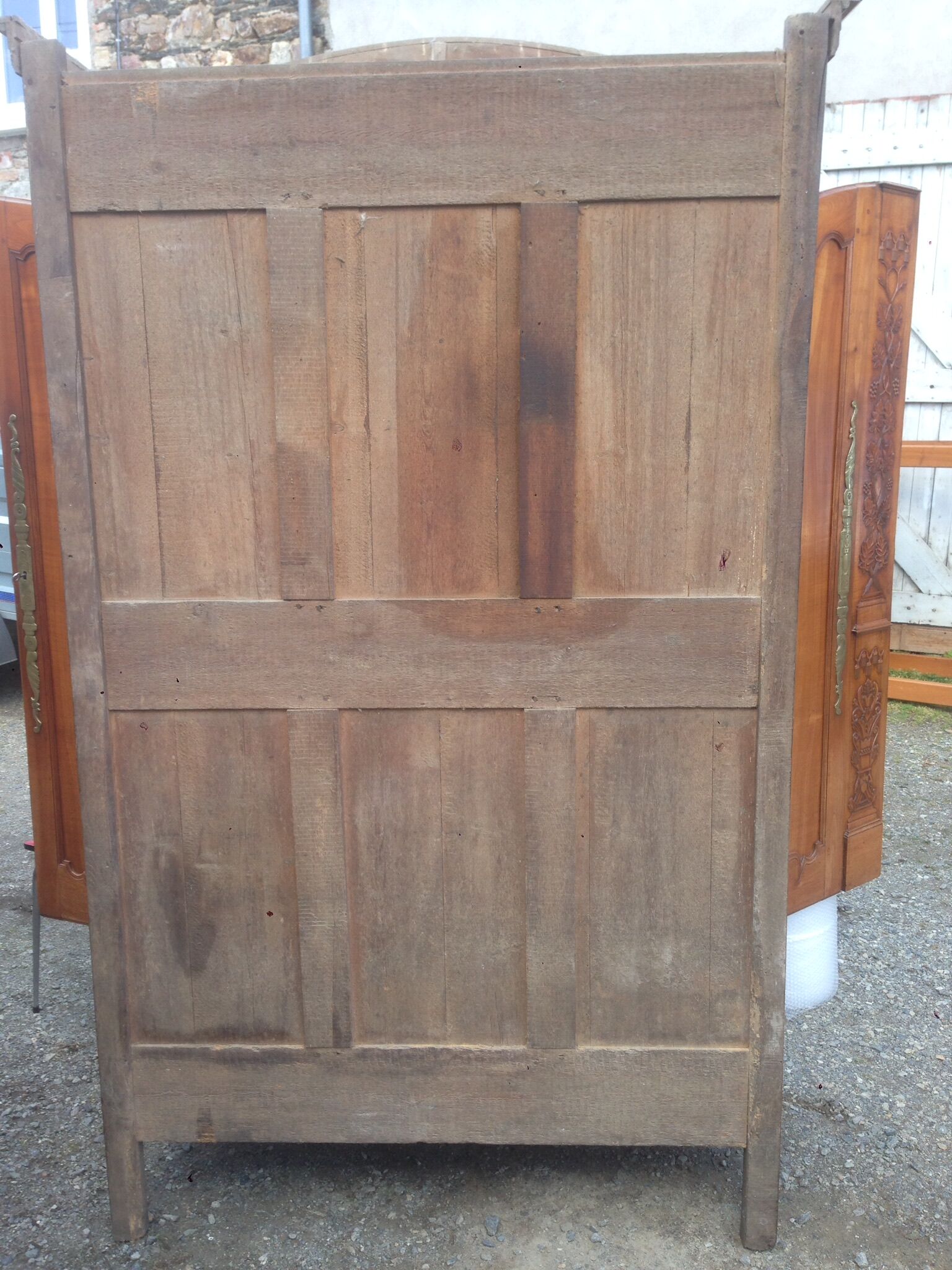 Armoire Louis XV Nantaise sculptée à grappes de raisin, chapeau de gendarme en cerisier fin 19eme.