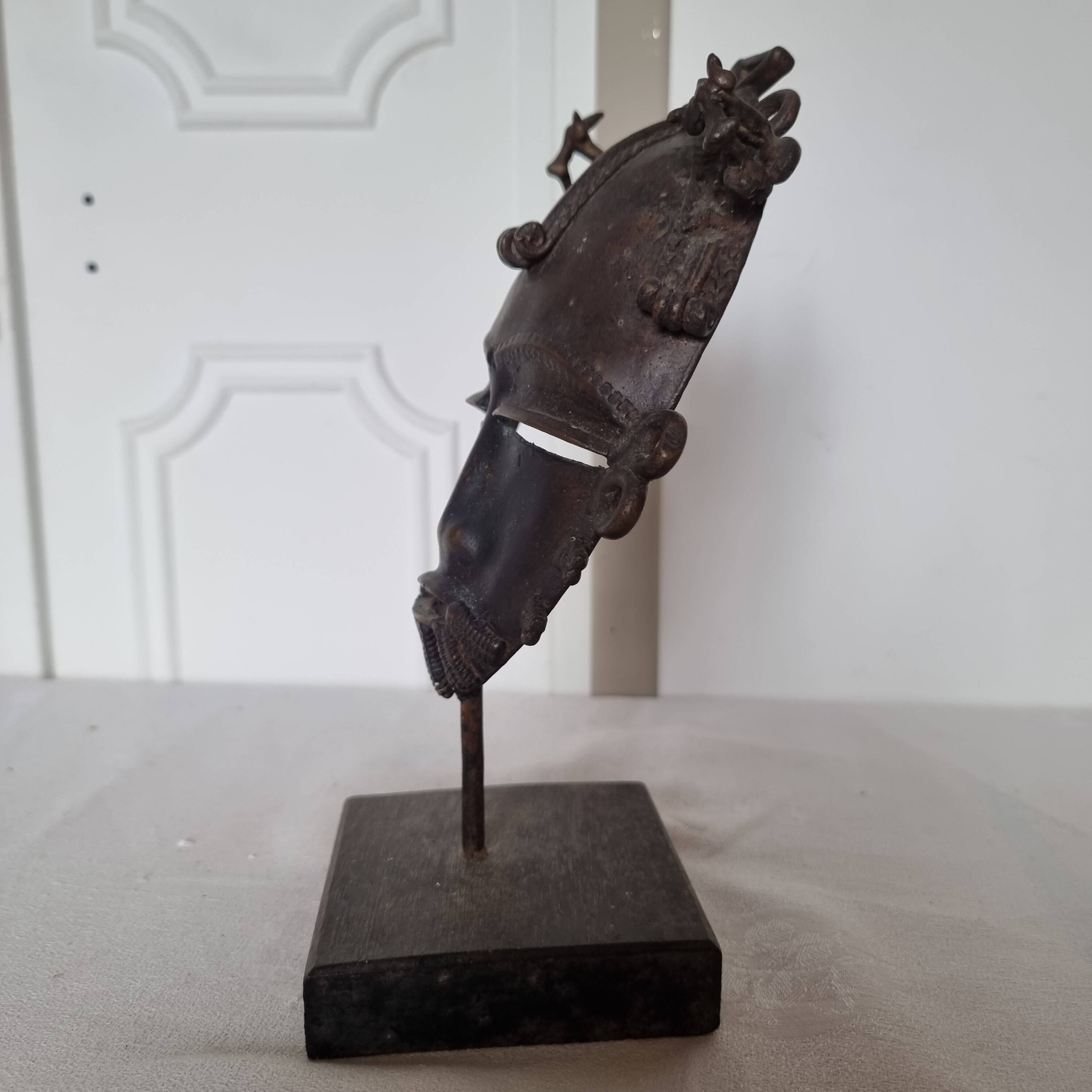 African bronze mask on pedestal, from Ivory Coast, dating