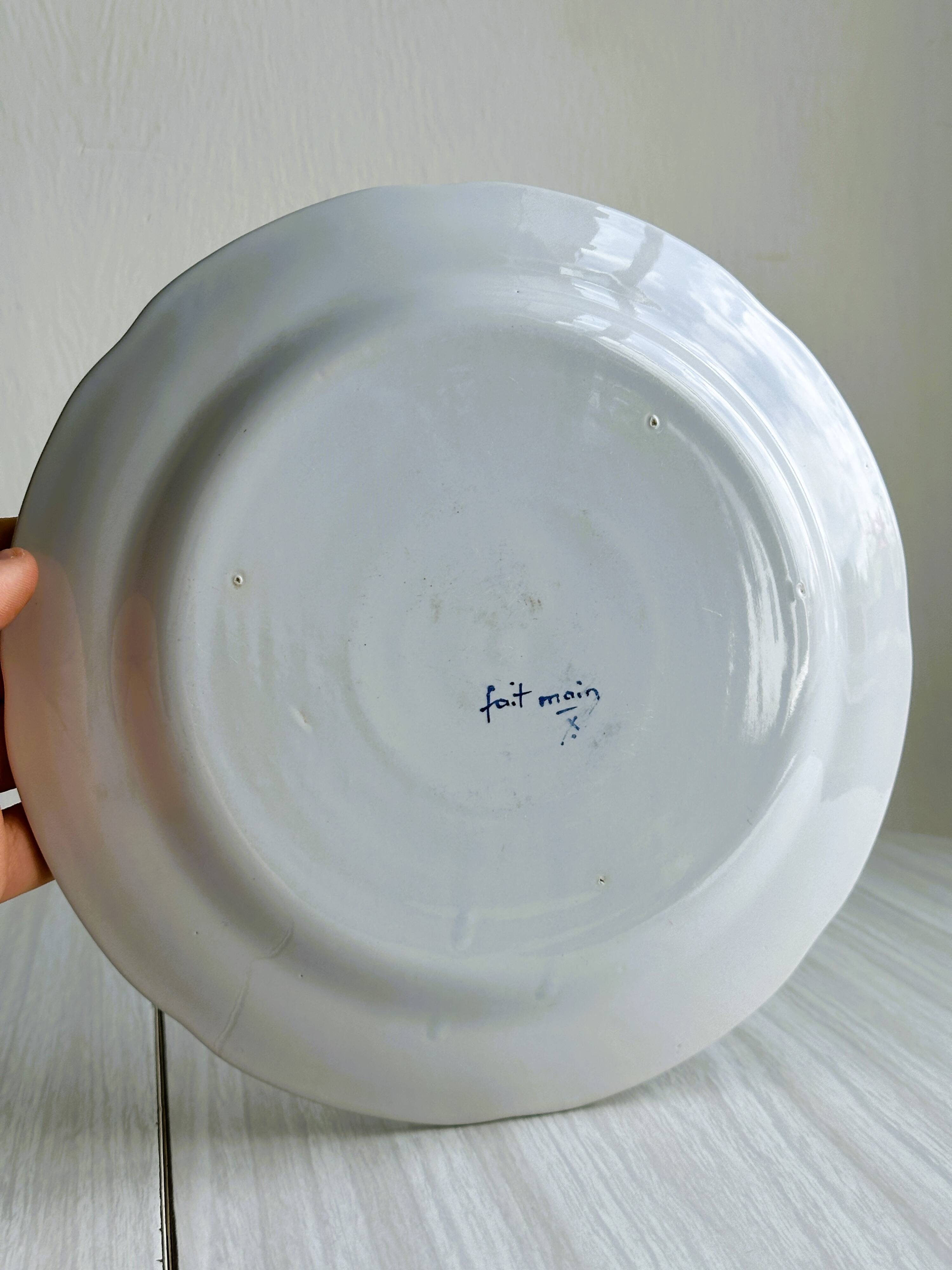 Hand-painted earthenware plate with landscape and bird decoration.