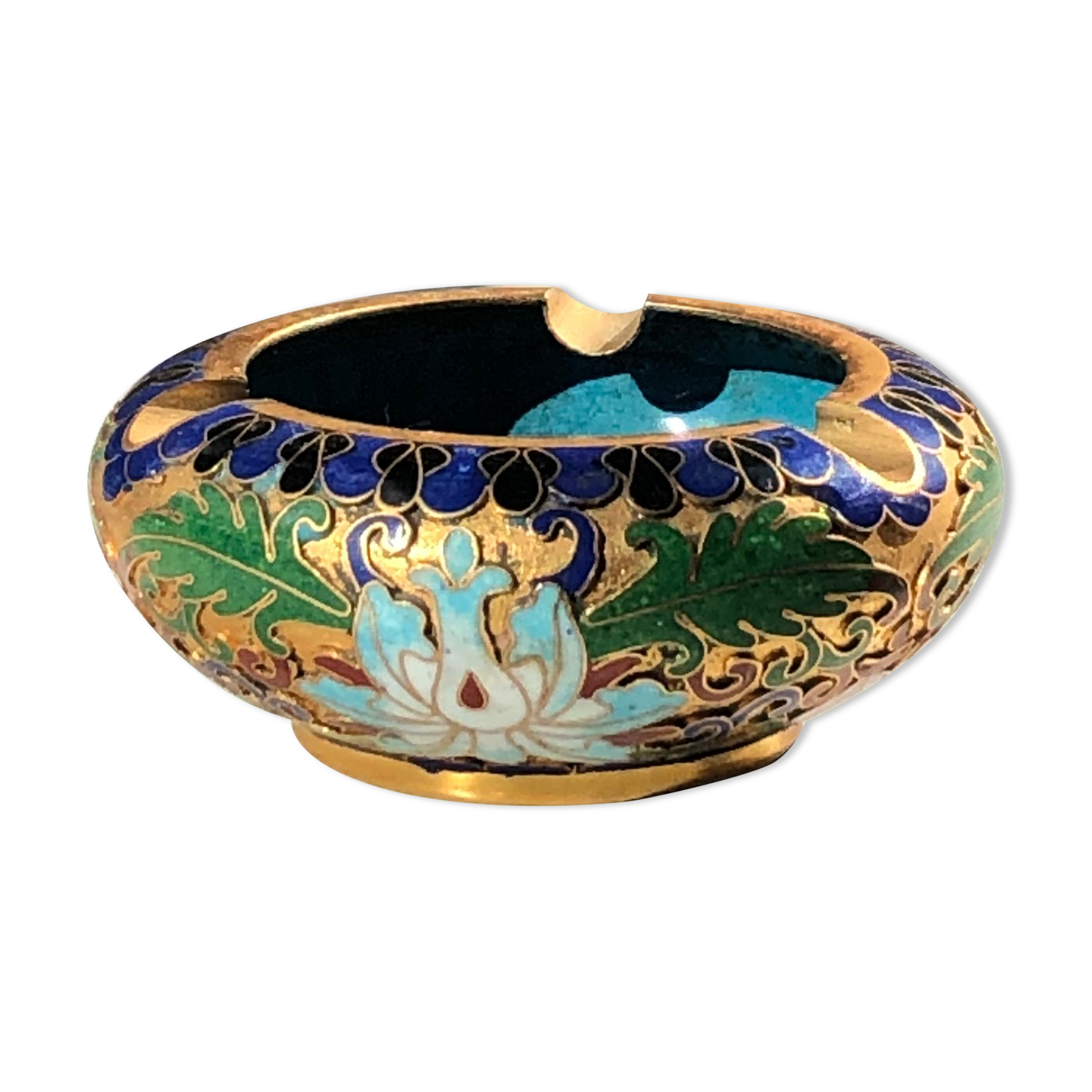 Ashtray floral floral ornament, plant in relief on a golden background.