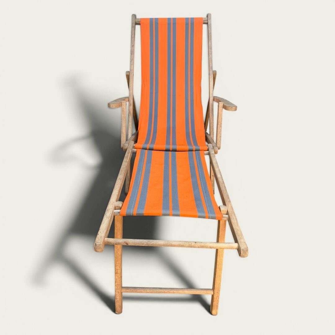 Vintage deck chair with orange and grey striped fabric, original patina.