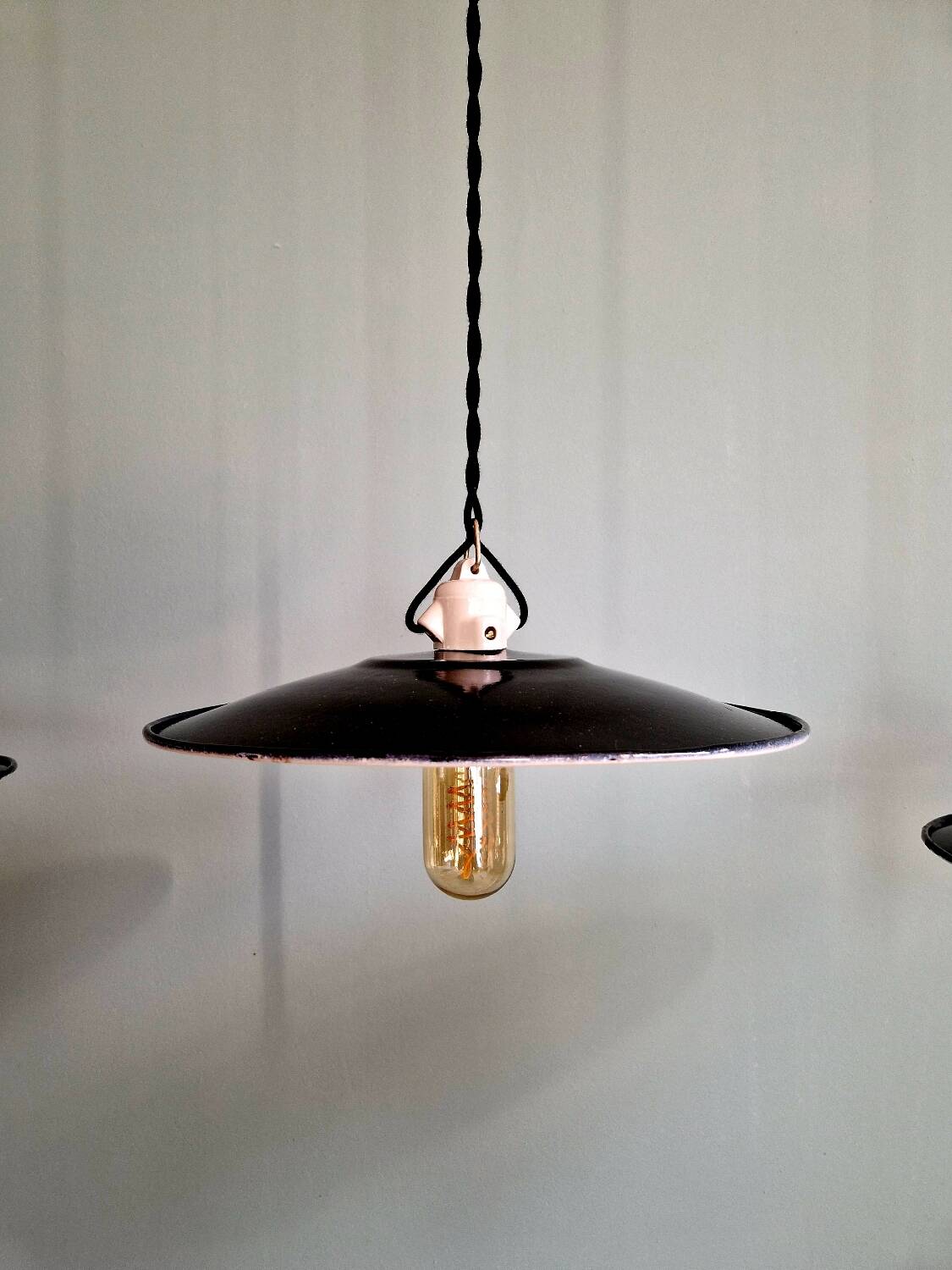 Three industrial suspensions in black enamelled sheet metal.