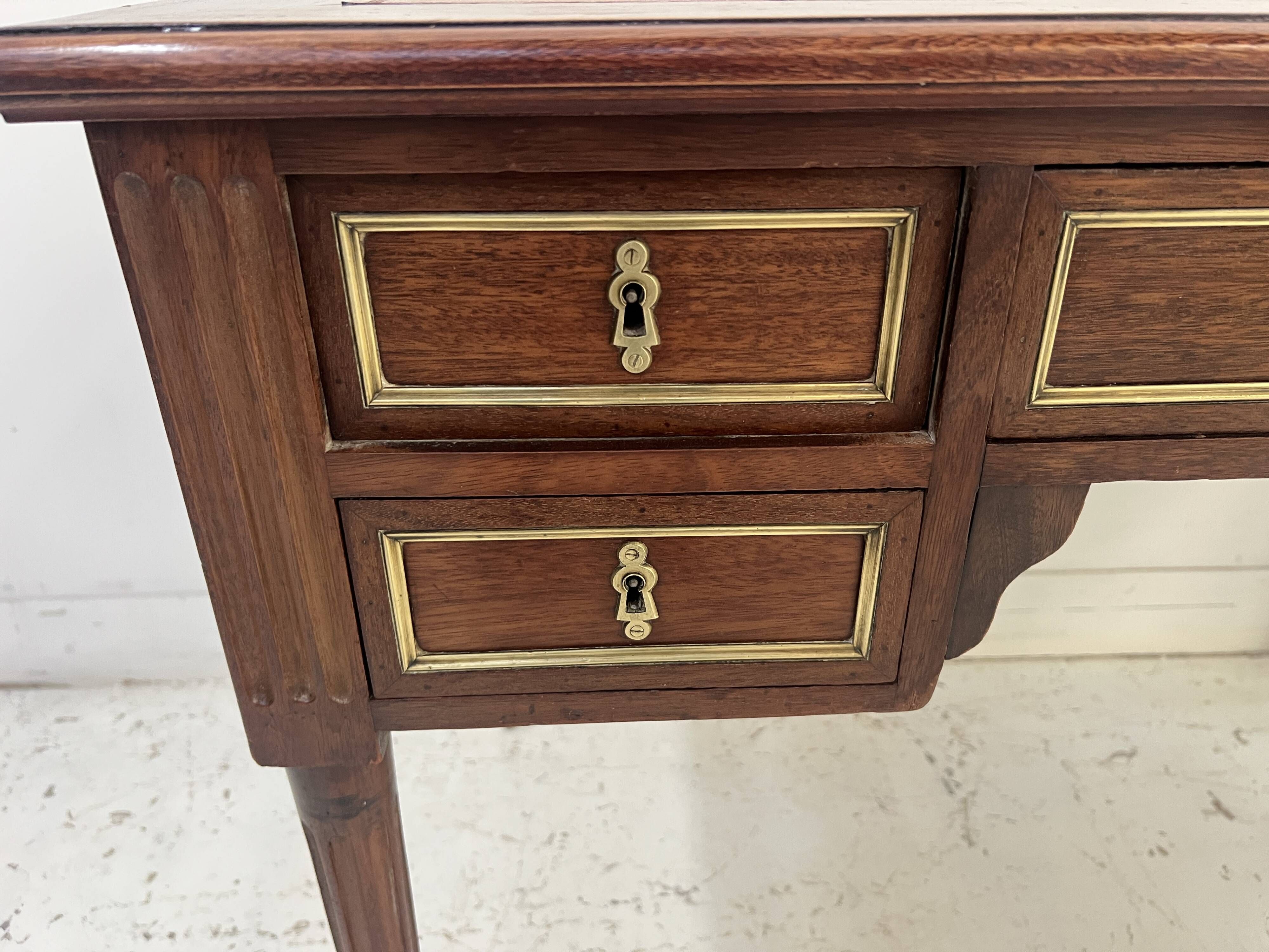 Louis XVI style desk in mahogany and mahogany veneer, 20th century.