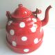 Old vintage kettle in red enamelled sheet metal, with white polka dots