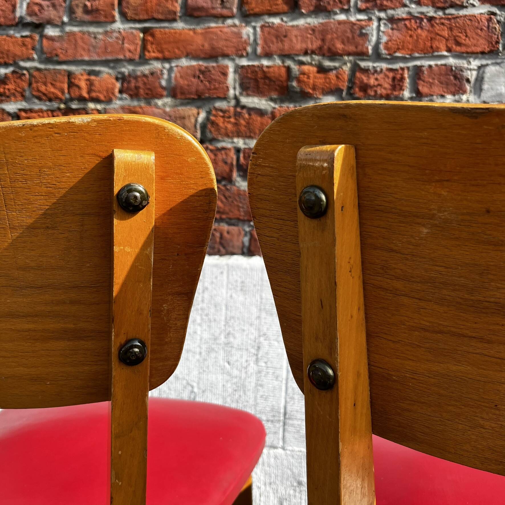 Set of 4 vintage bistro chairs in wood and red faux leather, with splayed legs.